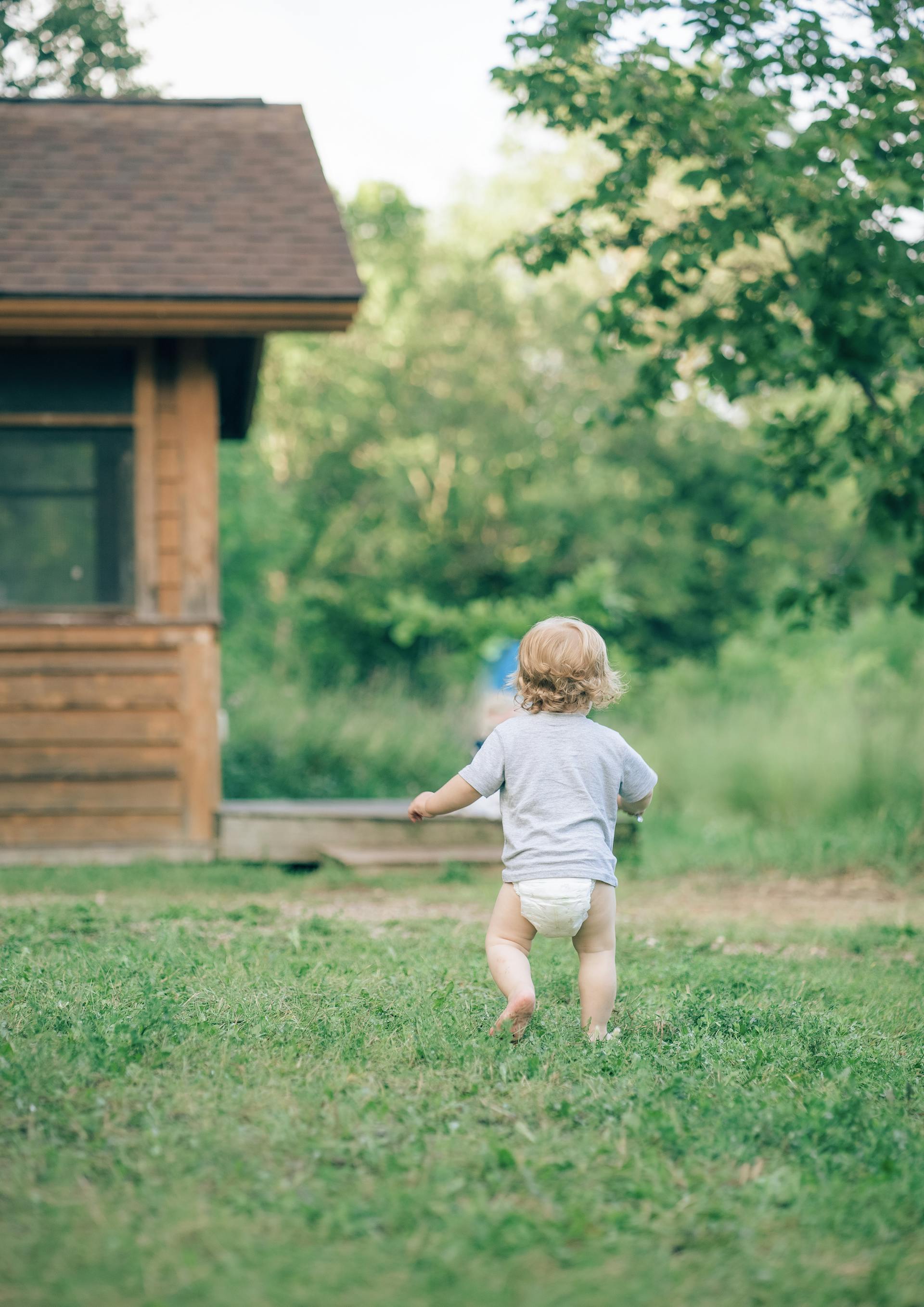 A back view of a toddler in a diaper running in the garden | Source: Pexels