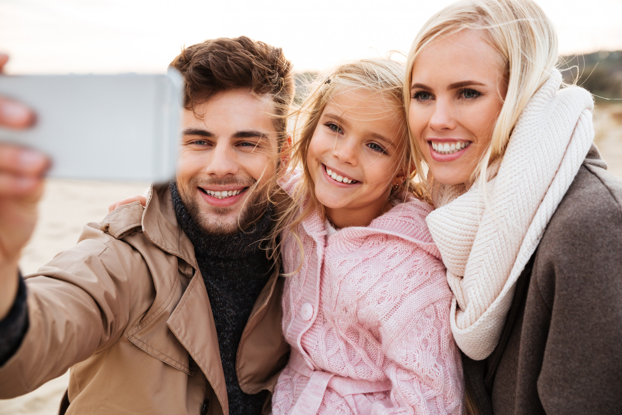 A man, child, and woman posing together for a selfie | Source: Freepik