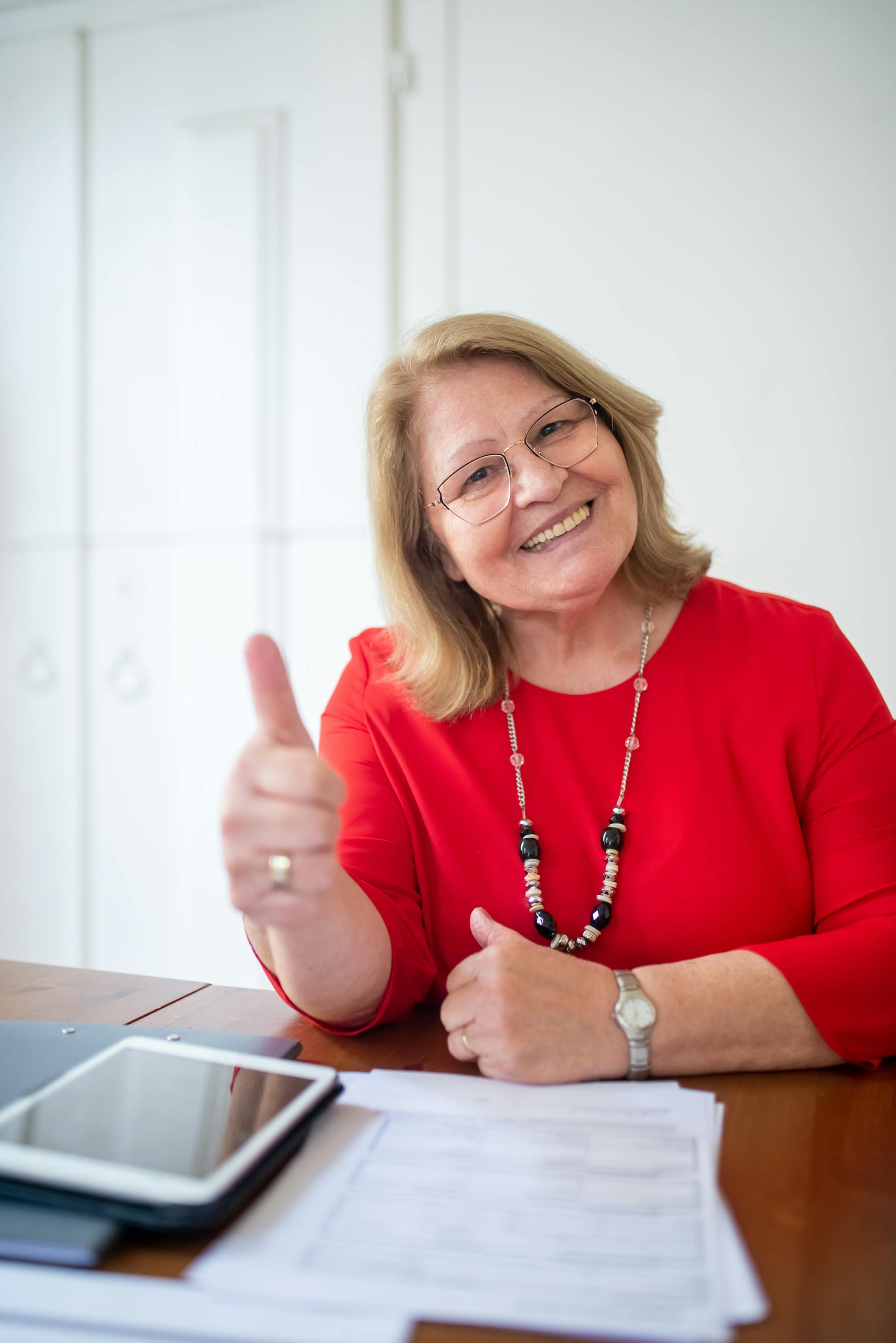 A woman in a red dress giving a thumbs up | Source: Pexels