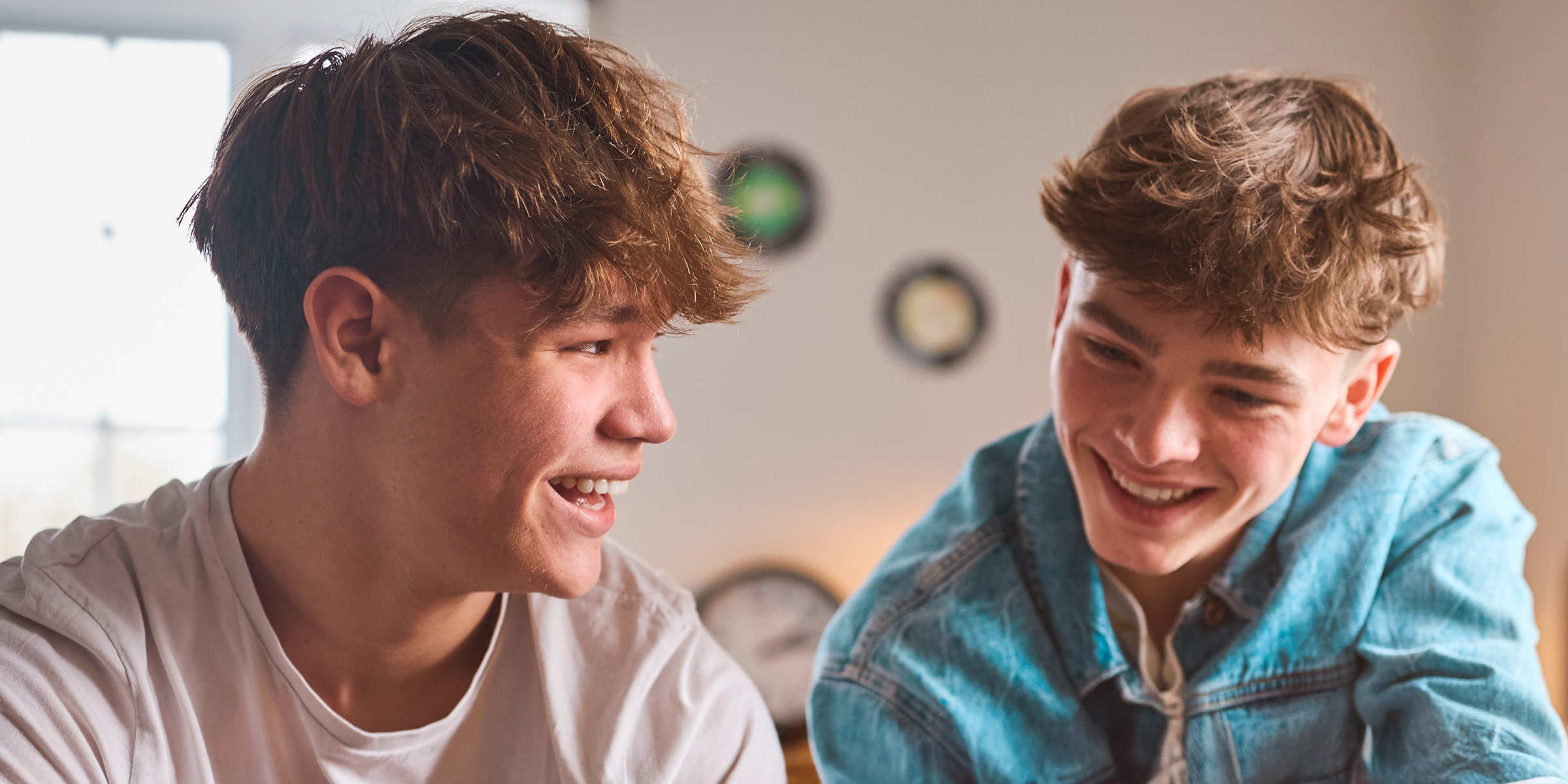 Two teenage boys laughing together | Source: Shutterstock