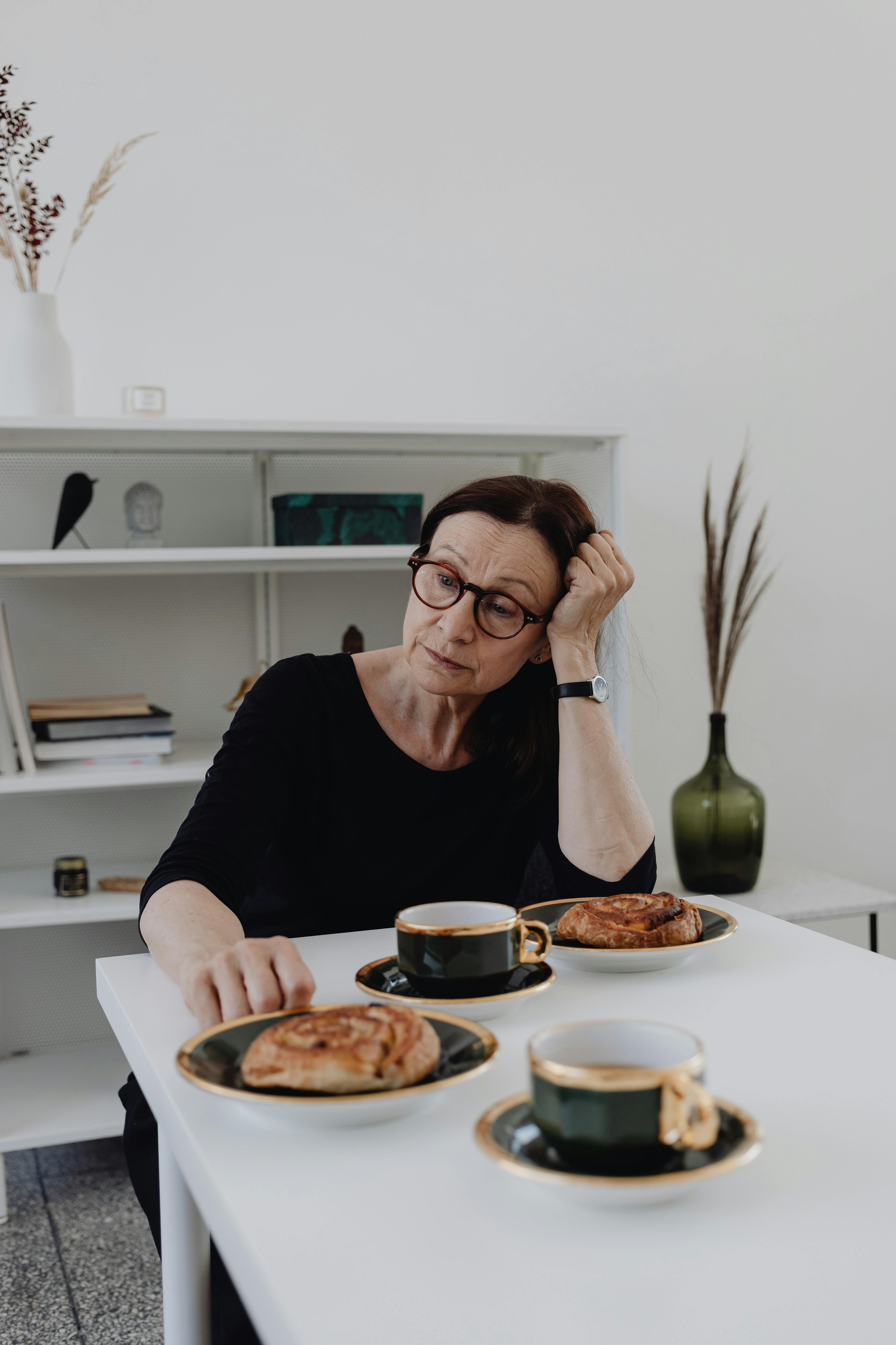 A sad woman sitting at a table | Source: Pexels