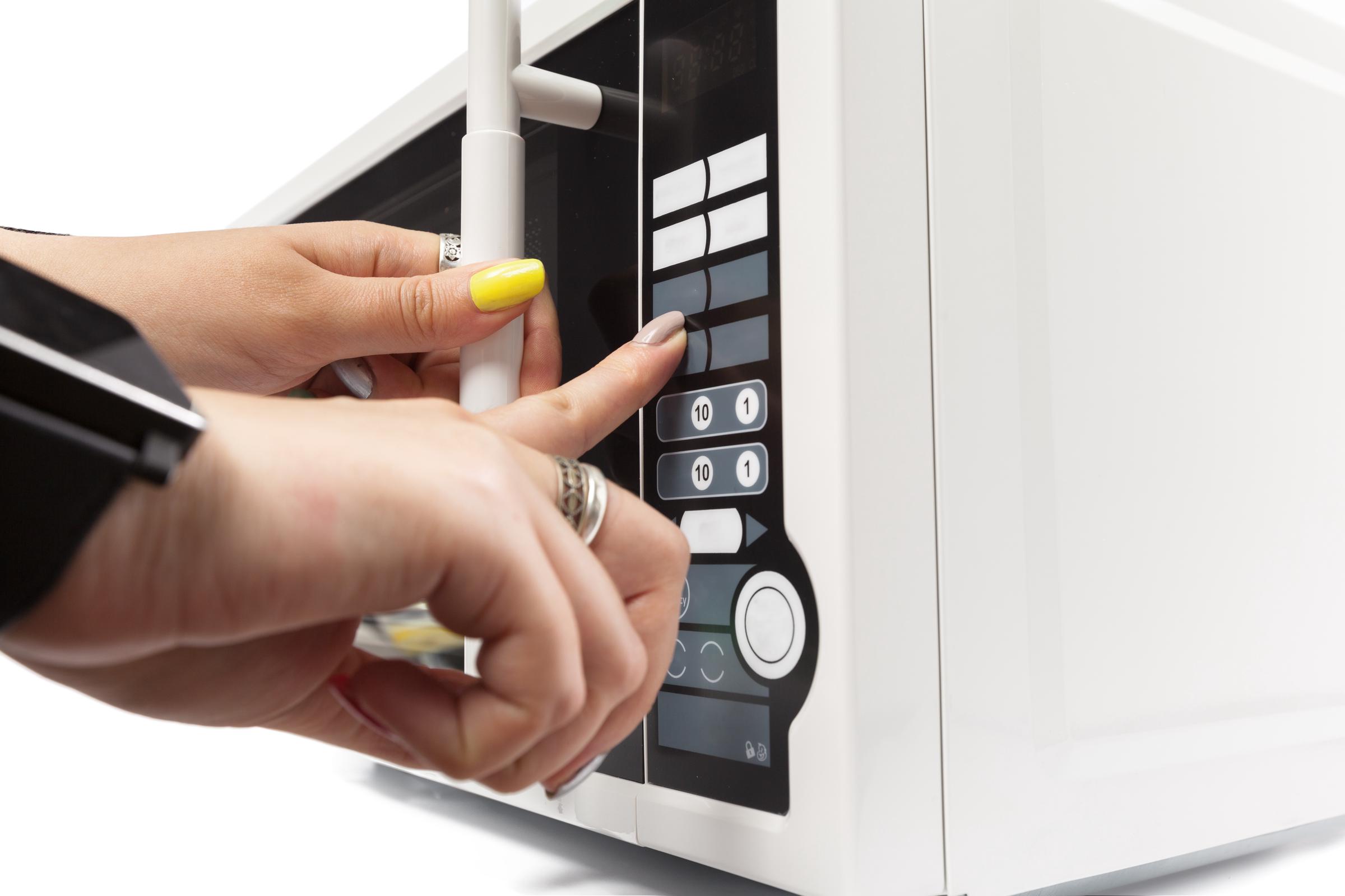 A woman using a microwave | Source: Freepik