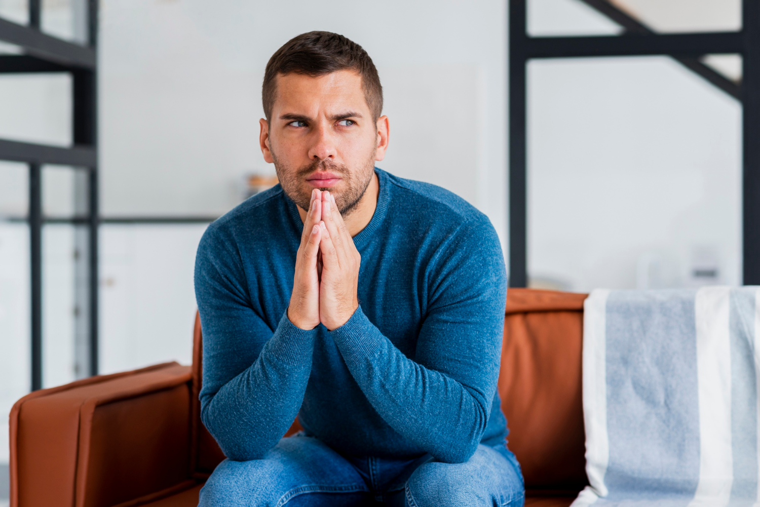 An anxious man sitting on the couch | Source: Freepik