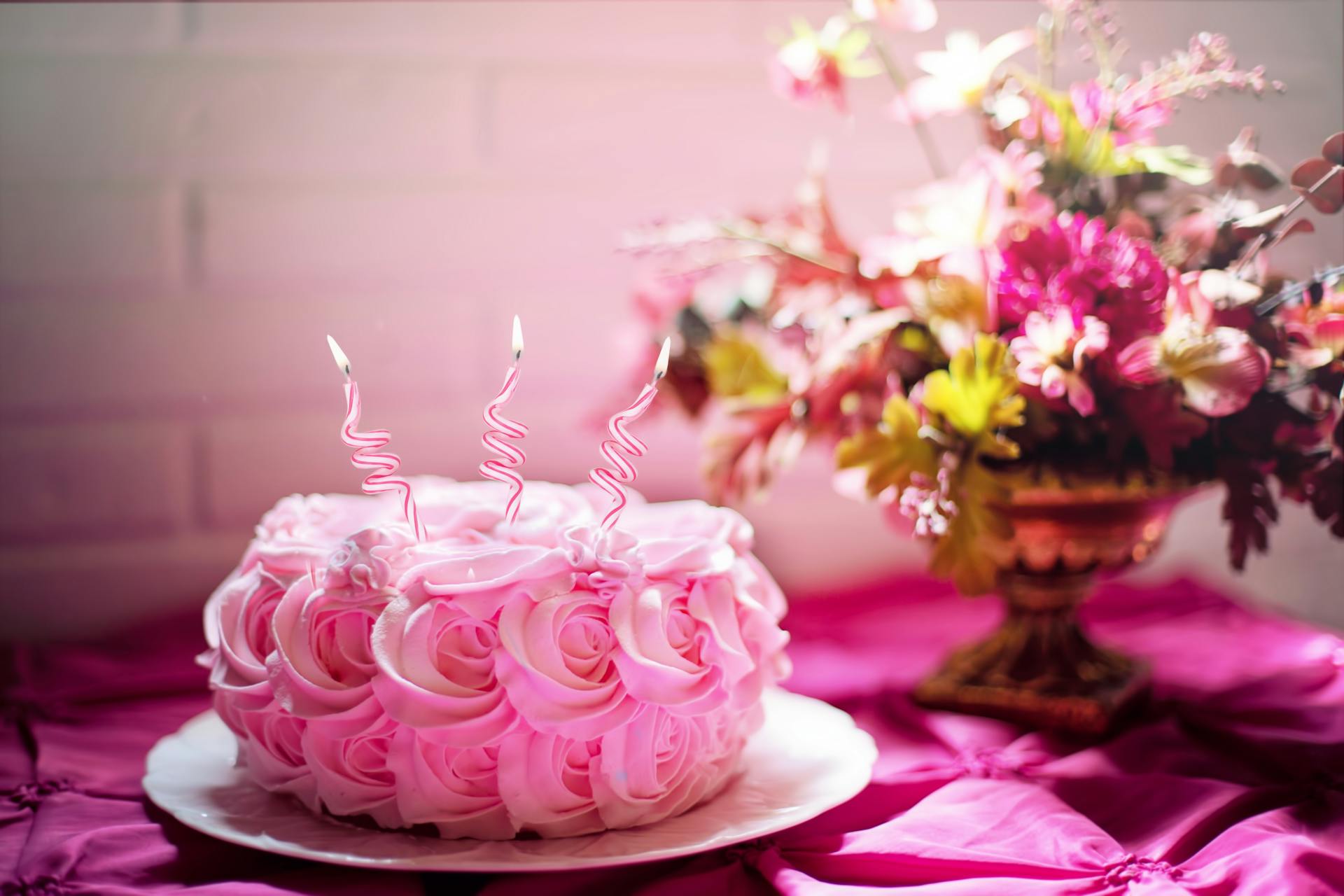A pink flower cake with candles | Source: Pexels