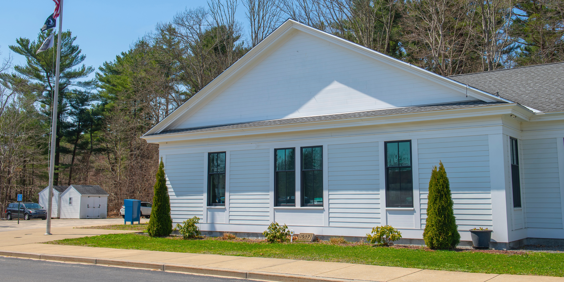 A white single-story house with black-trimmed windows and a neatly kept yard | Source: Shutterstock