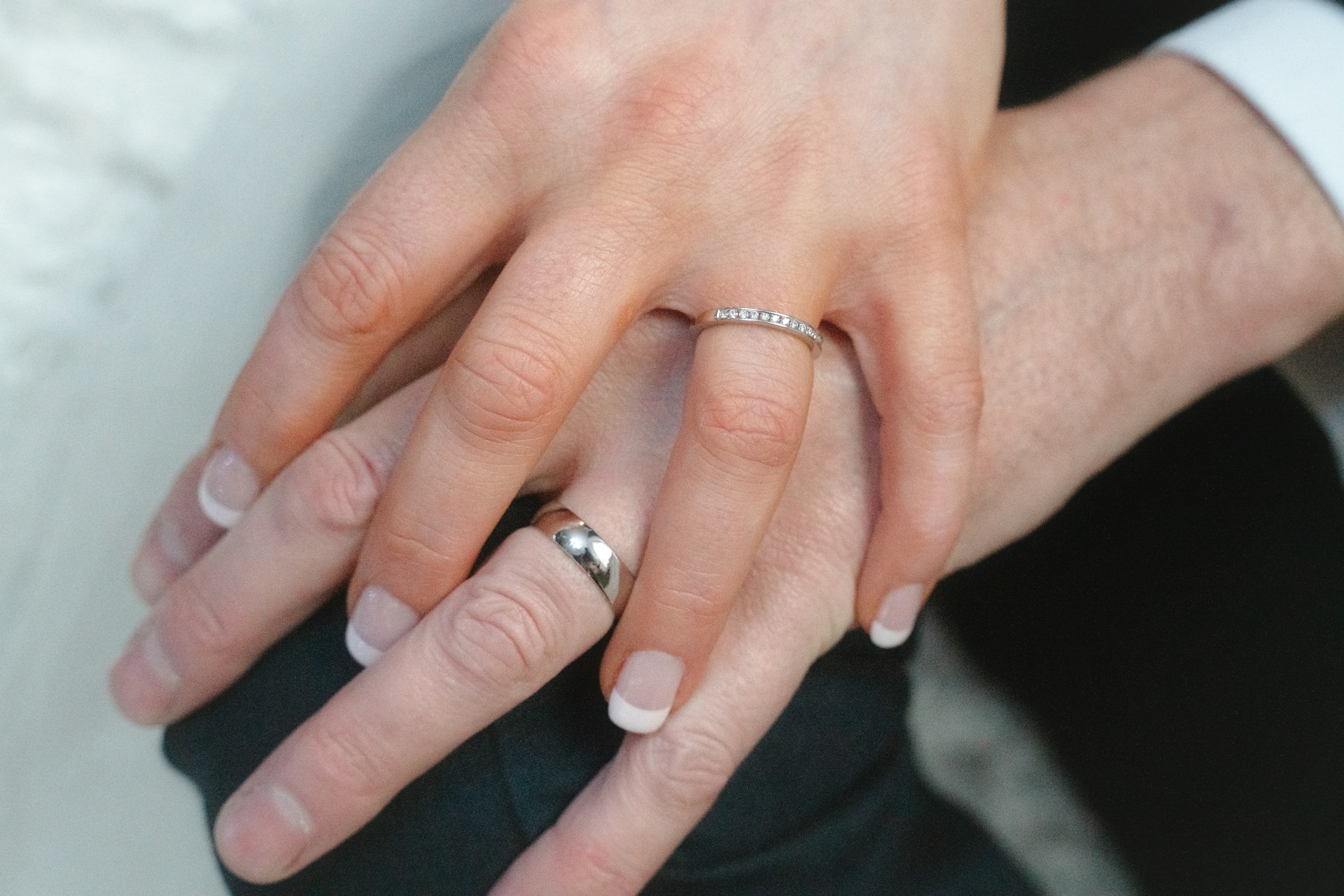A couple holding their hands, flaunting their wedding rings | Source: Unsplash