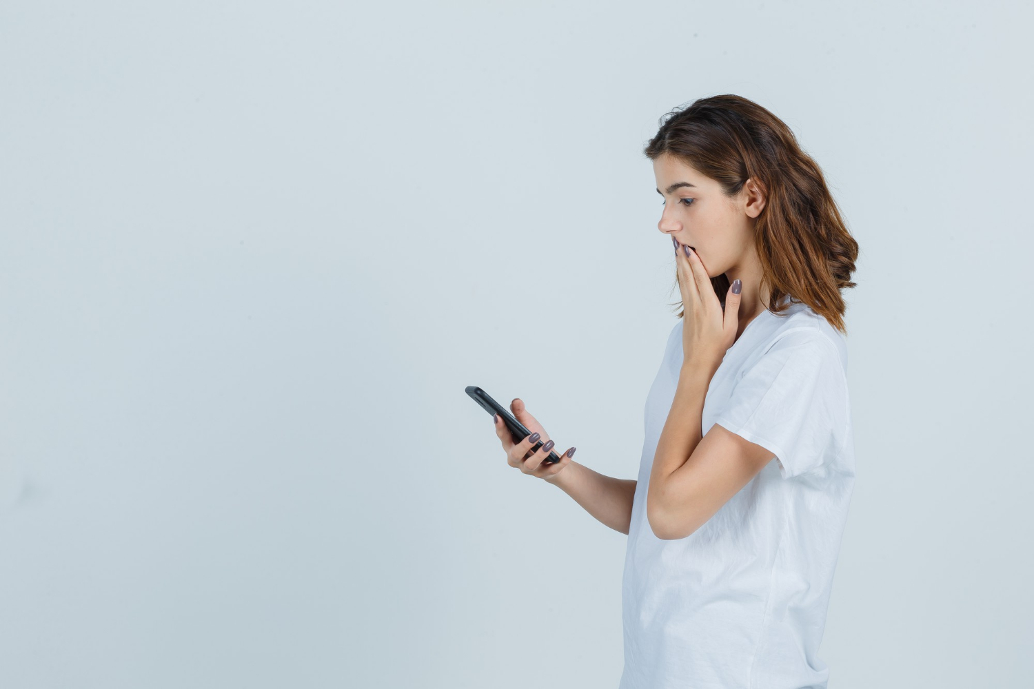 A concerned woman staring at her phone | Source: Freepik