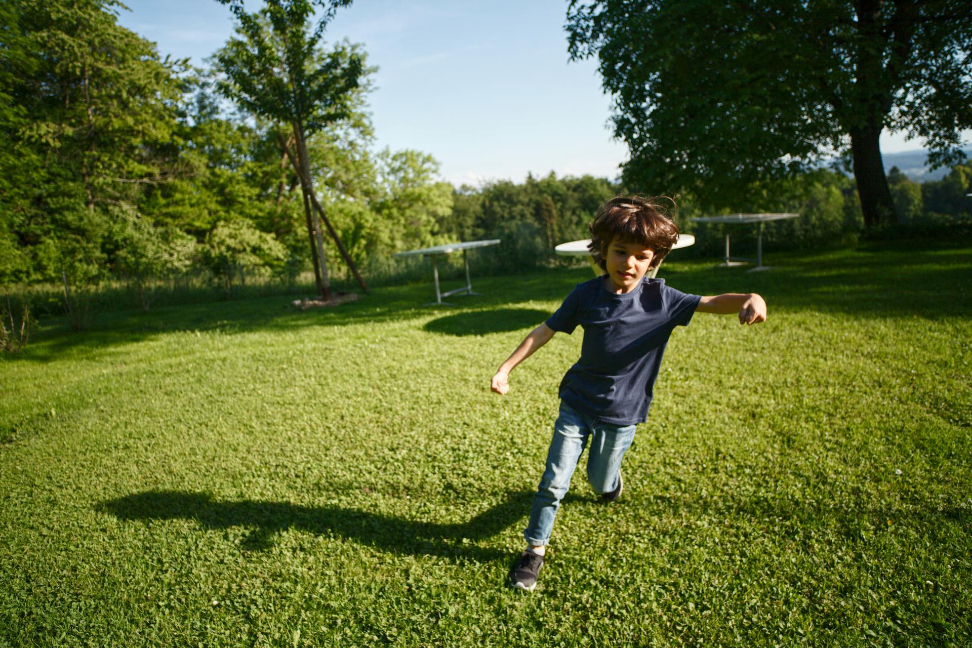 A boy running on the grass | Source: Pexels