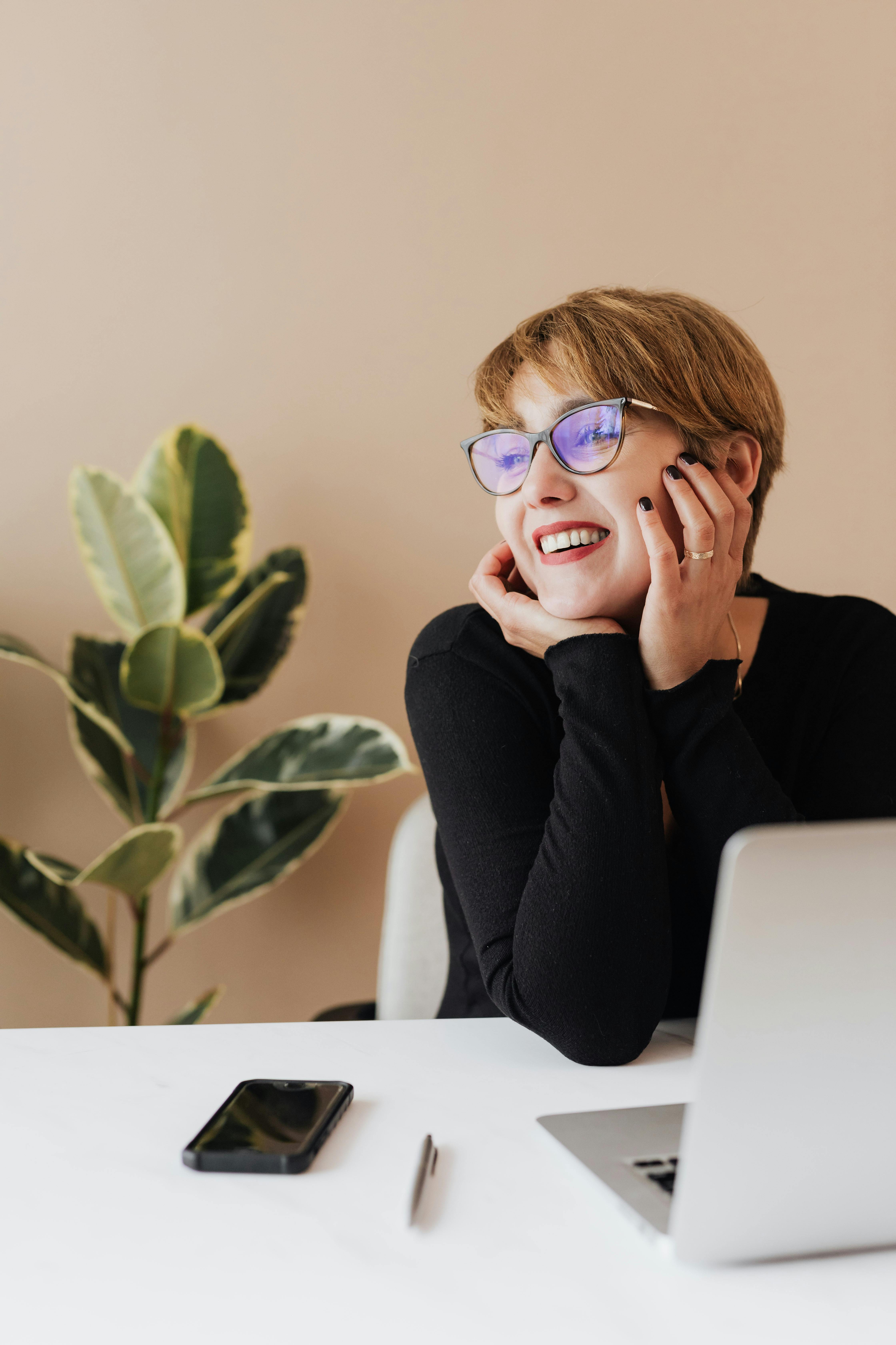 Woman smiling while looking at her laptop | Source: Pexels
