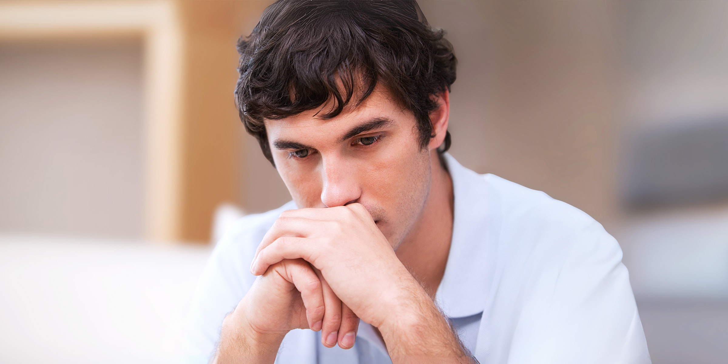 A thoughtful man sitting in a living room | Source: Shutterstock