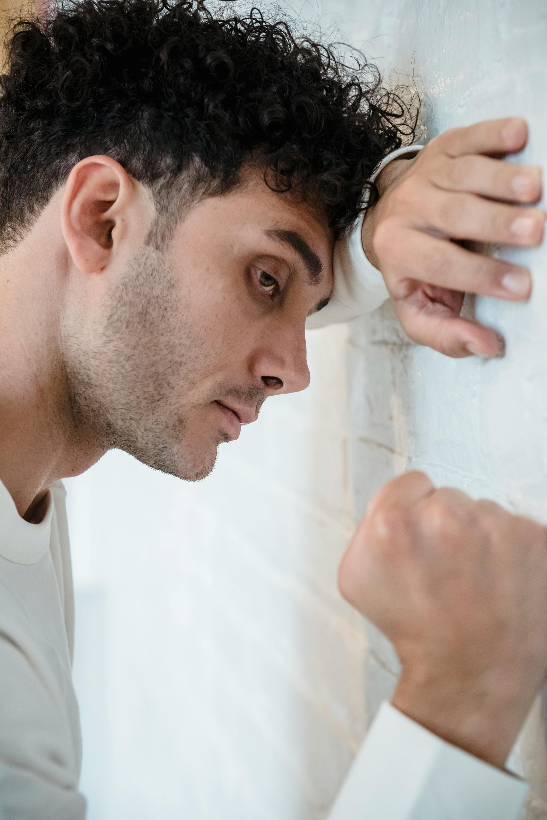 A man pressing his fist against a wall | Source: Pexels