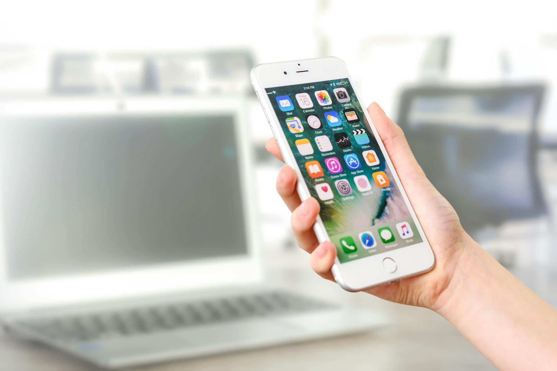 A woman holding a cell phone in an office | Source: Pexels