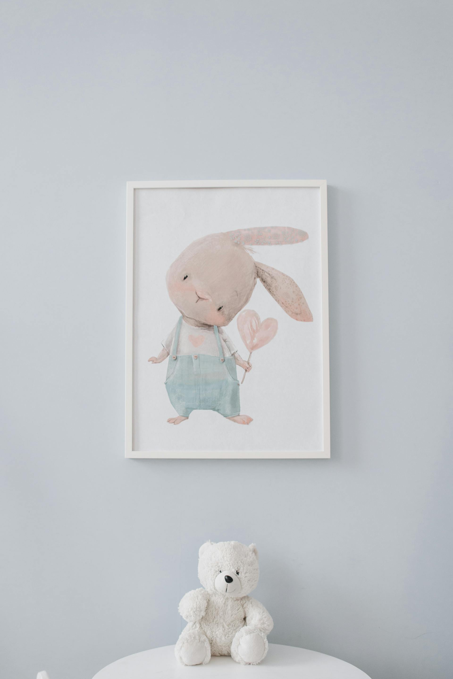 Pluszowy miś leżący pod ramą ścienną | Źródło: Pexels