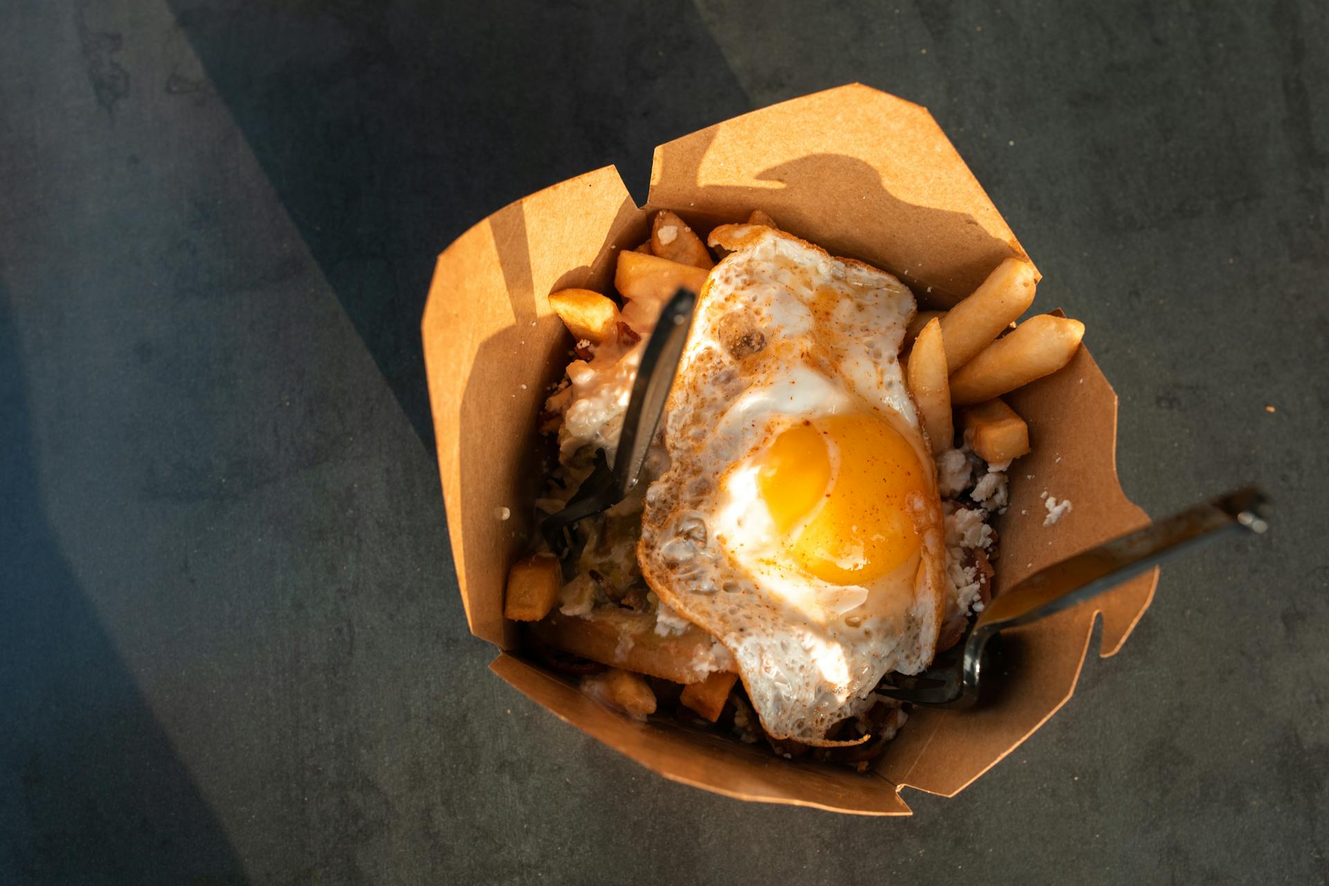 An egg with fries in a takeout box | Source: Pexels