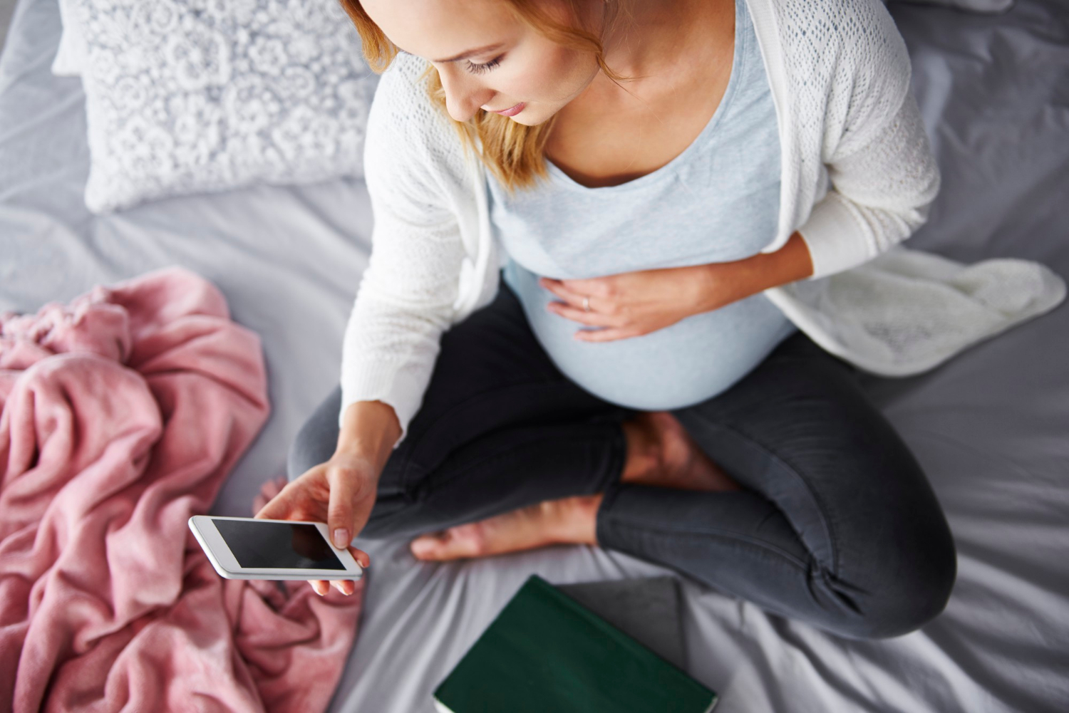A pregnant woman looking at her phone | Source: Freepik