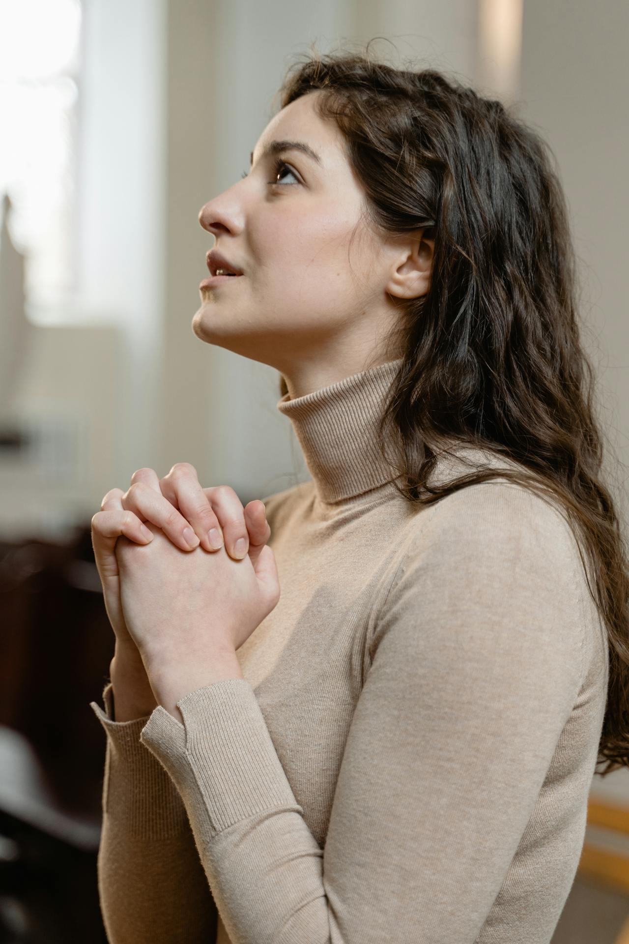 A desperate young woman in a church | Source: Pexels