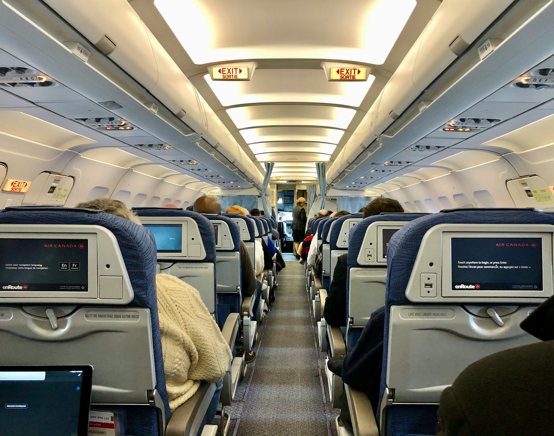 Flight passengers seated in the economy aisle | Source: Unsplash