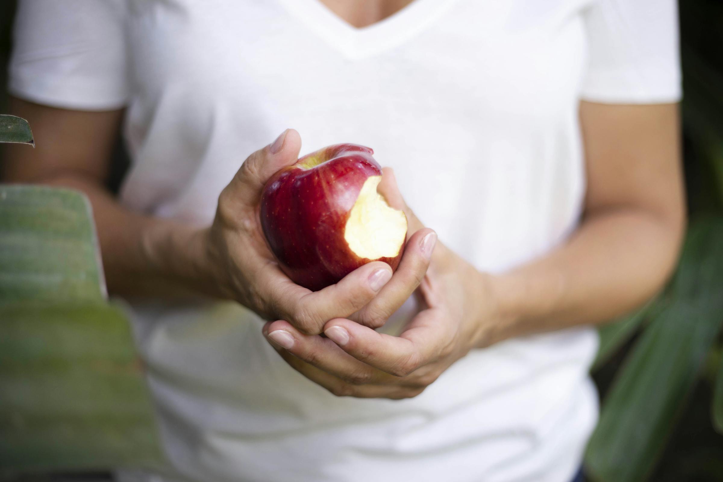 A woman holding a bitten apple | Source: Pexels