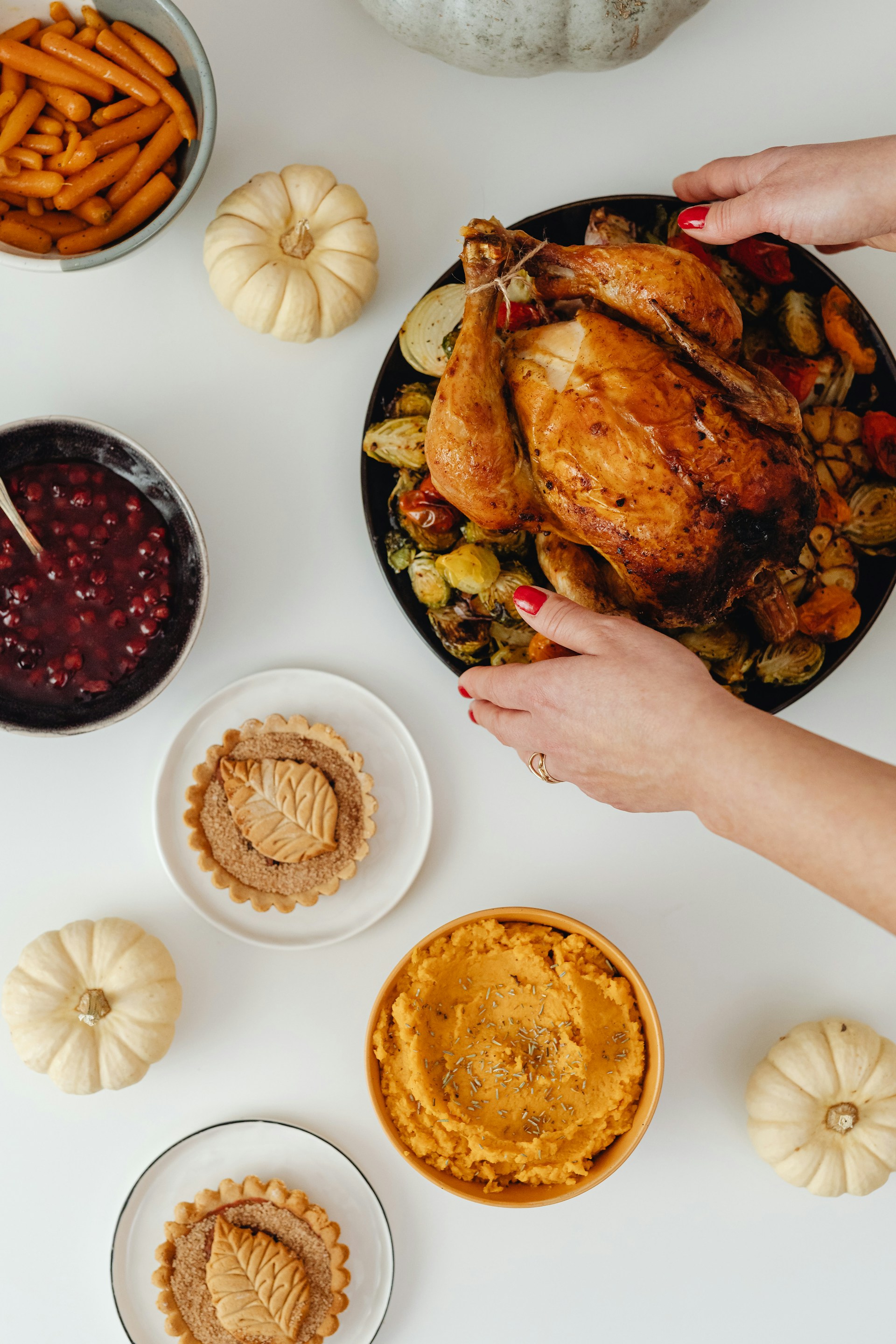 A woman placing a plate of chicken roast on the table | Source: Unsplash