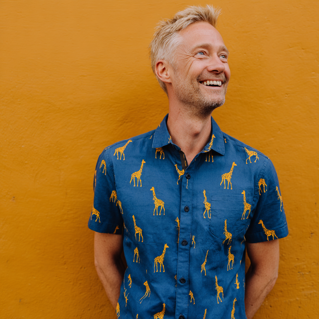 A smiling man wearing a giraffe-printed shirt | Source: Midjourney