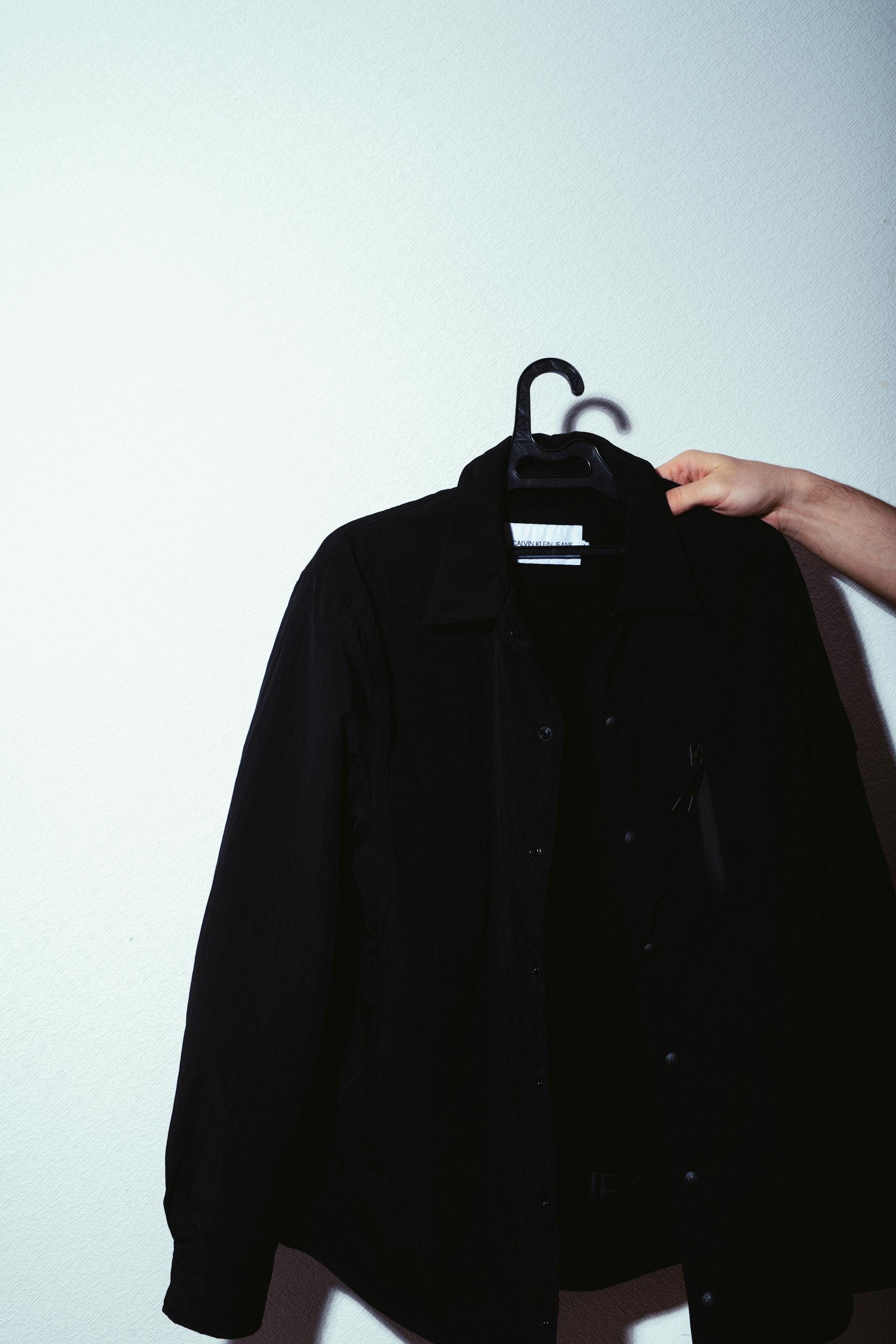 A person holding a jacket on a hanger | Source: Pexels