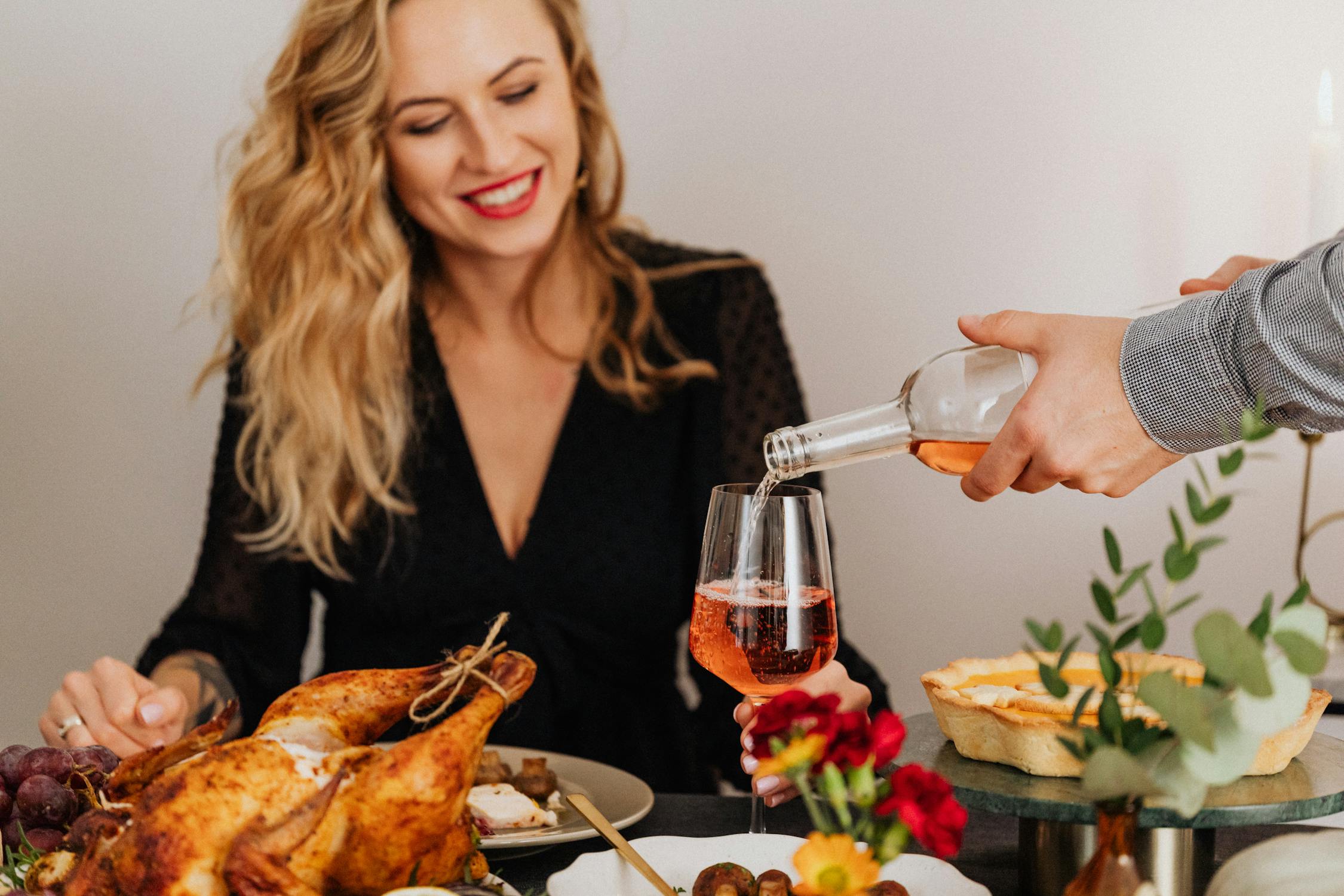 A smiling woman at a Thanksgiving dinner | Source: Pexels