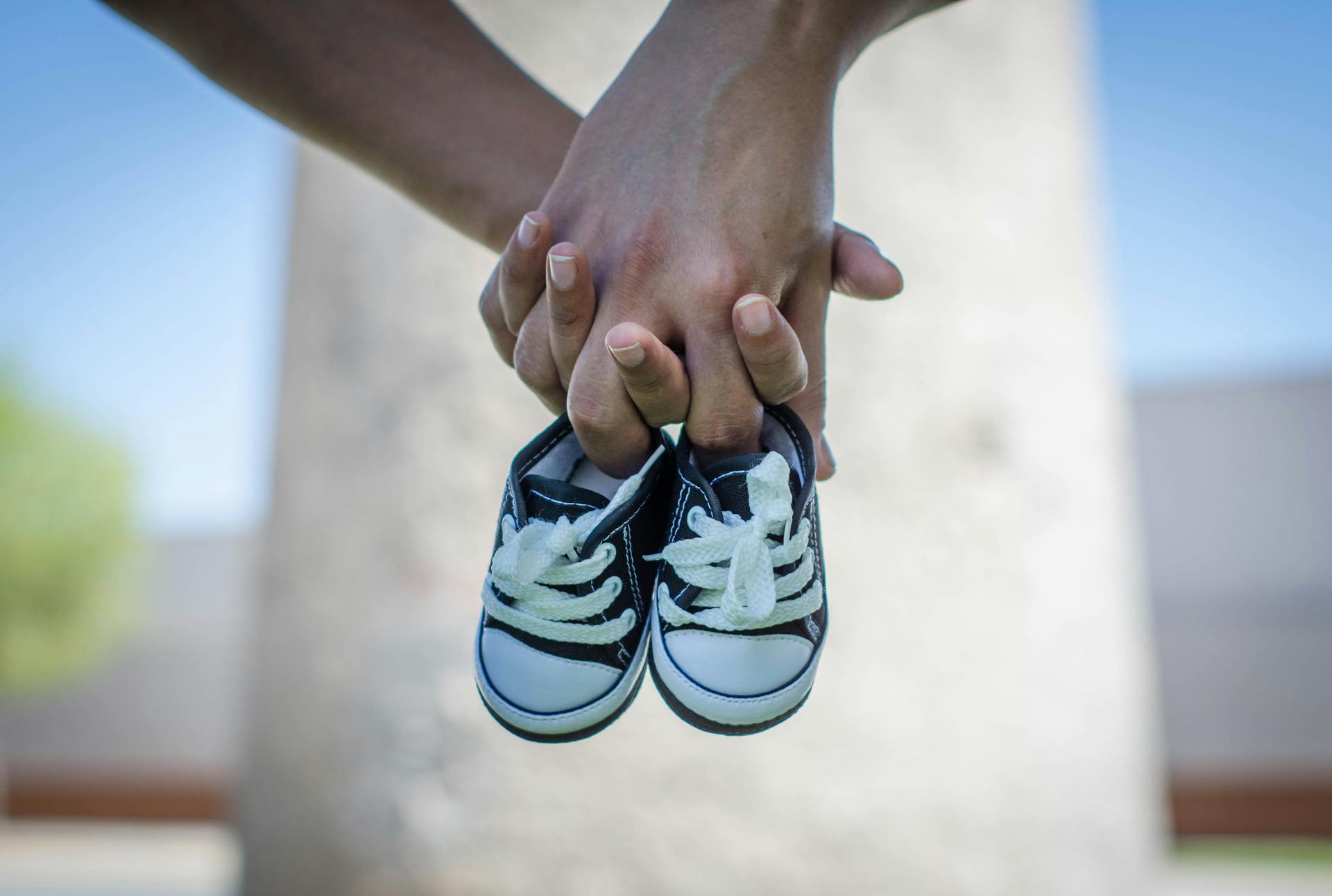 A couple holding baby shoes | Source: Pexels