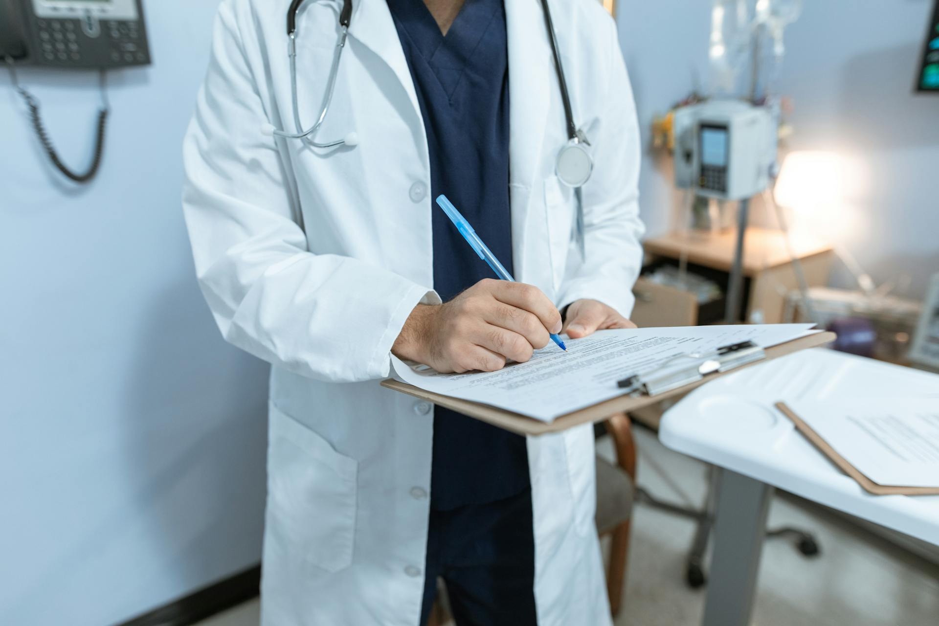 A doctor writing on a paper | Source: Pexels