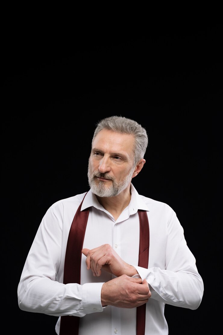 A smiling mature man looking to his side | Source: Freepik