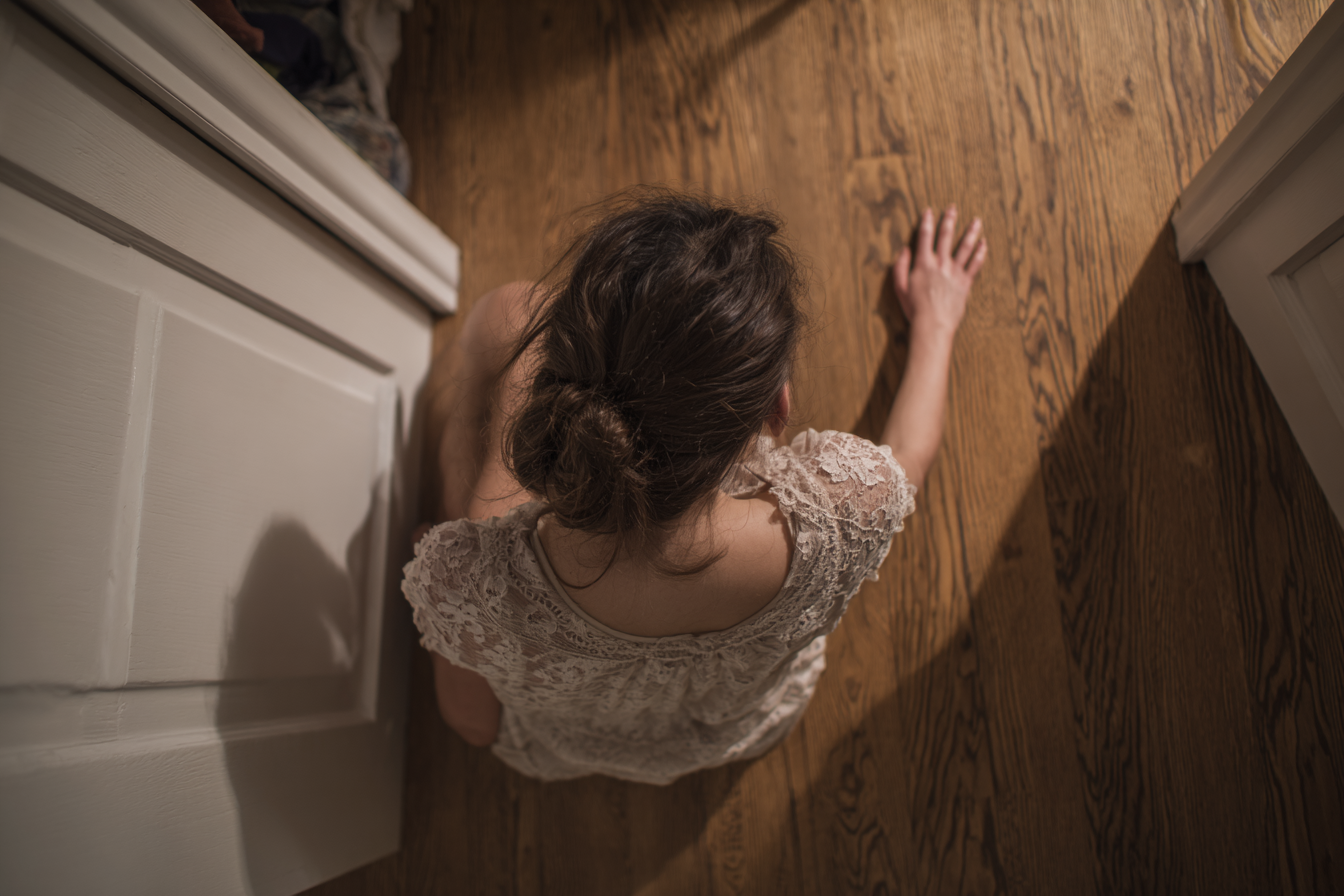 A woman examining a closet floor | Source: Midjourney