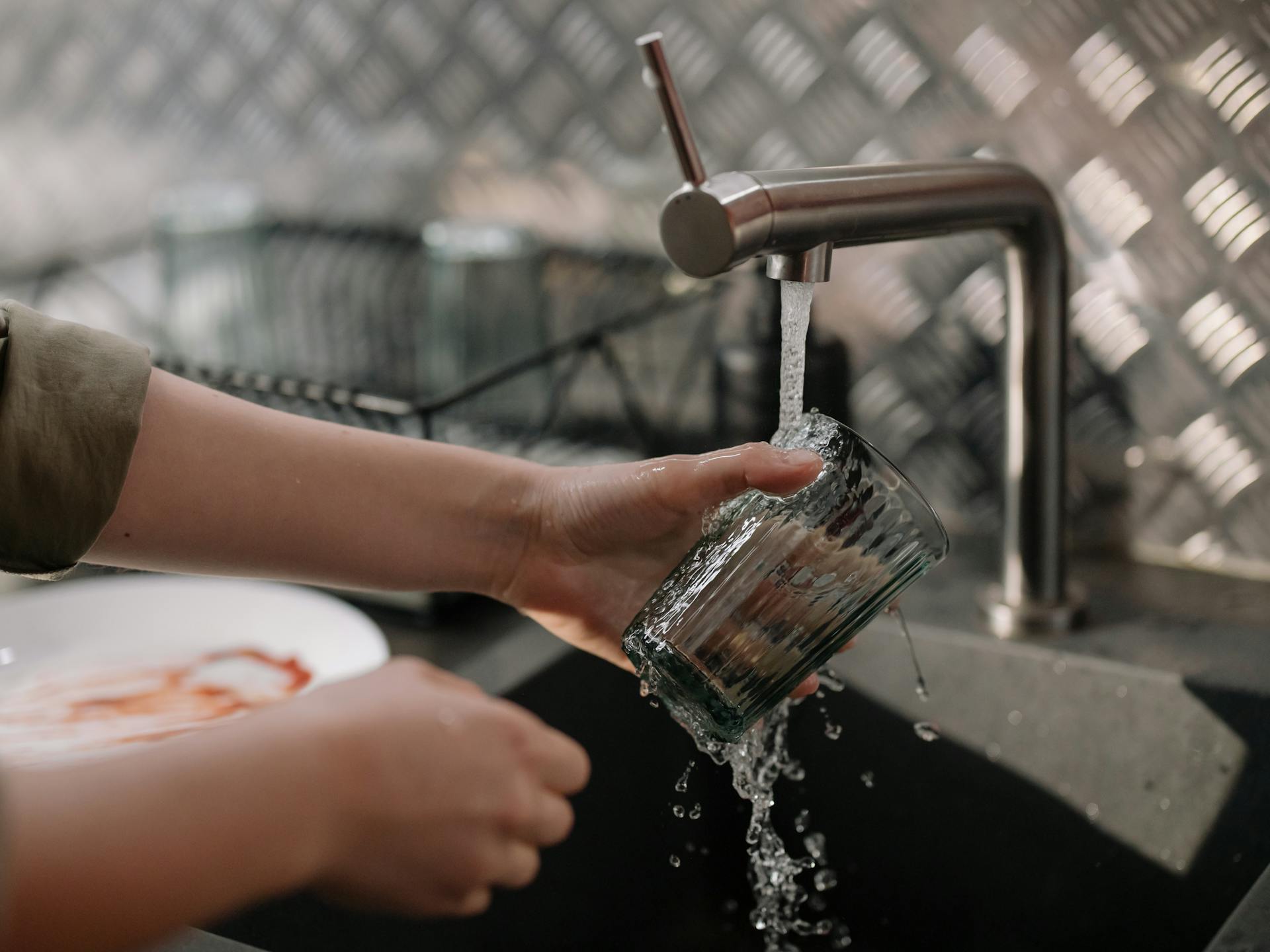 A man washing a glass | Source: Pexels