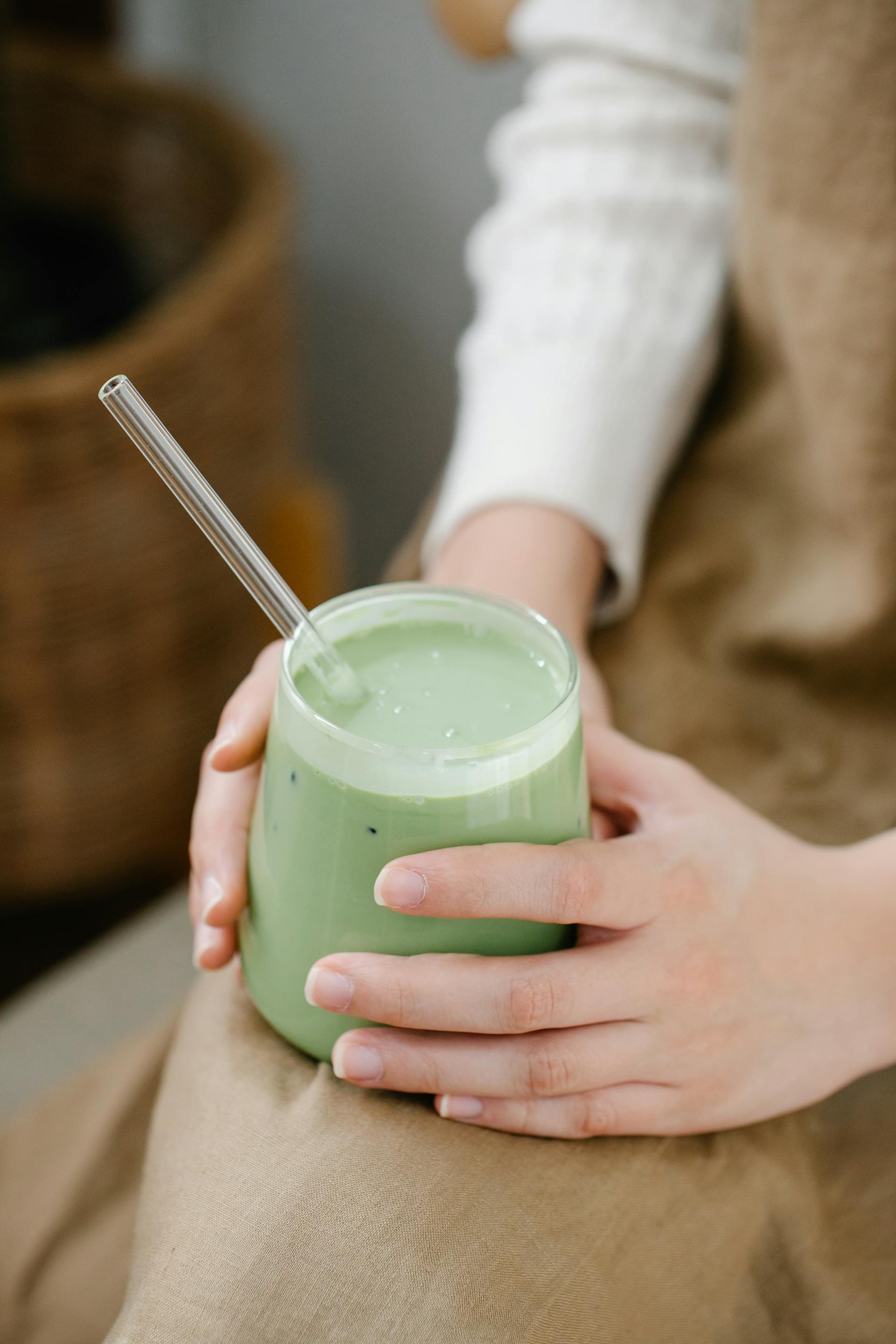 A woman holding a green smoothie | Source: Pexels