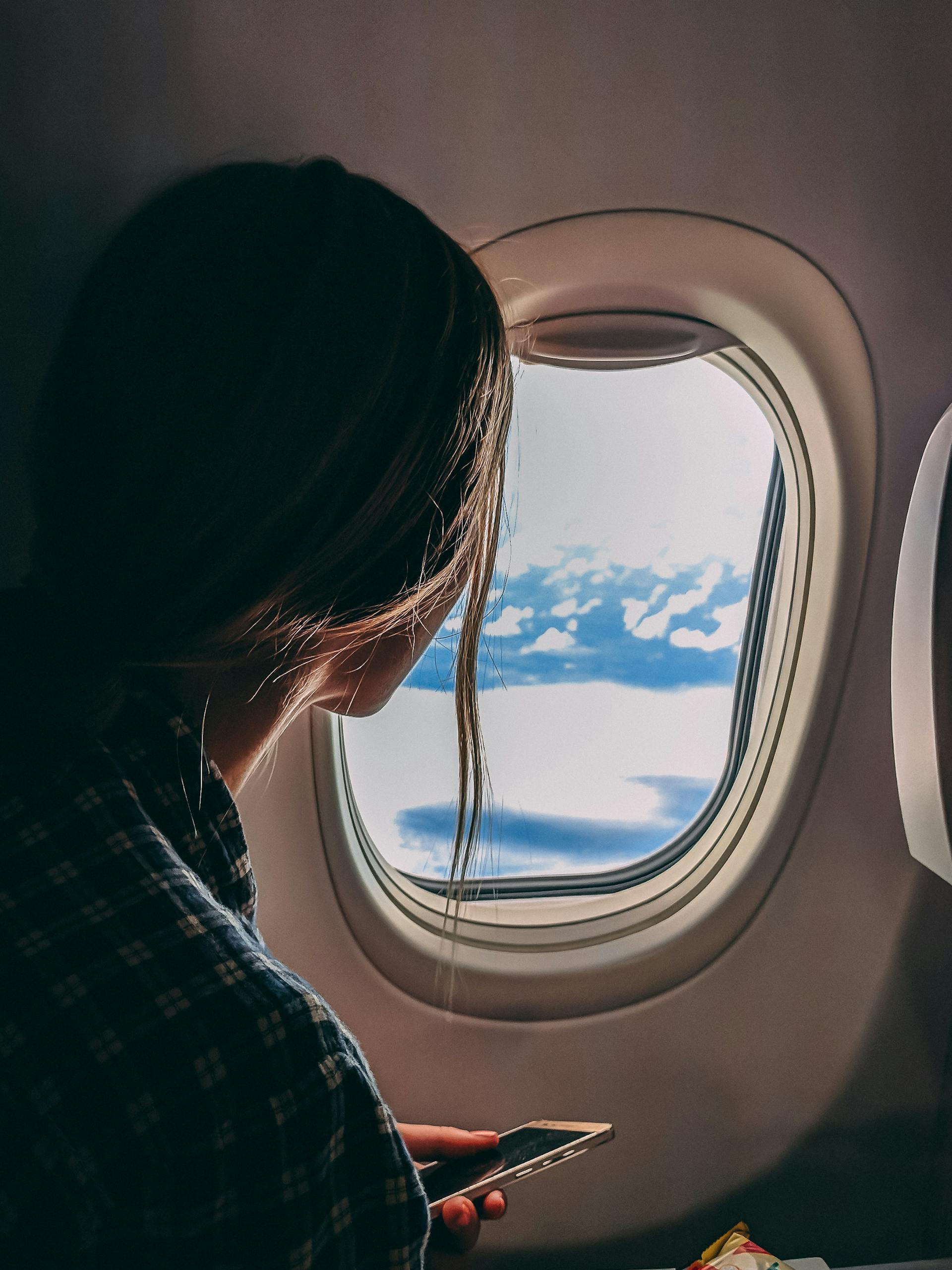 A woman looking out a plane window | Source: Pexels