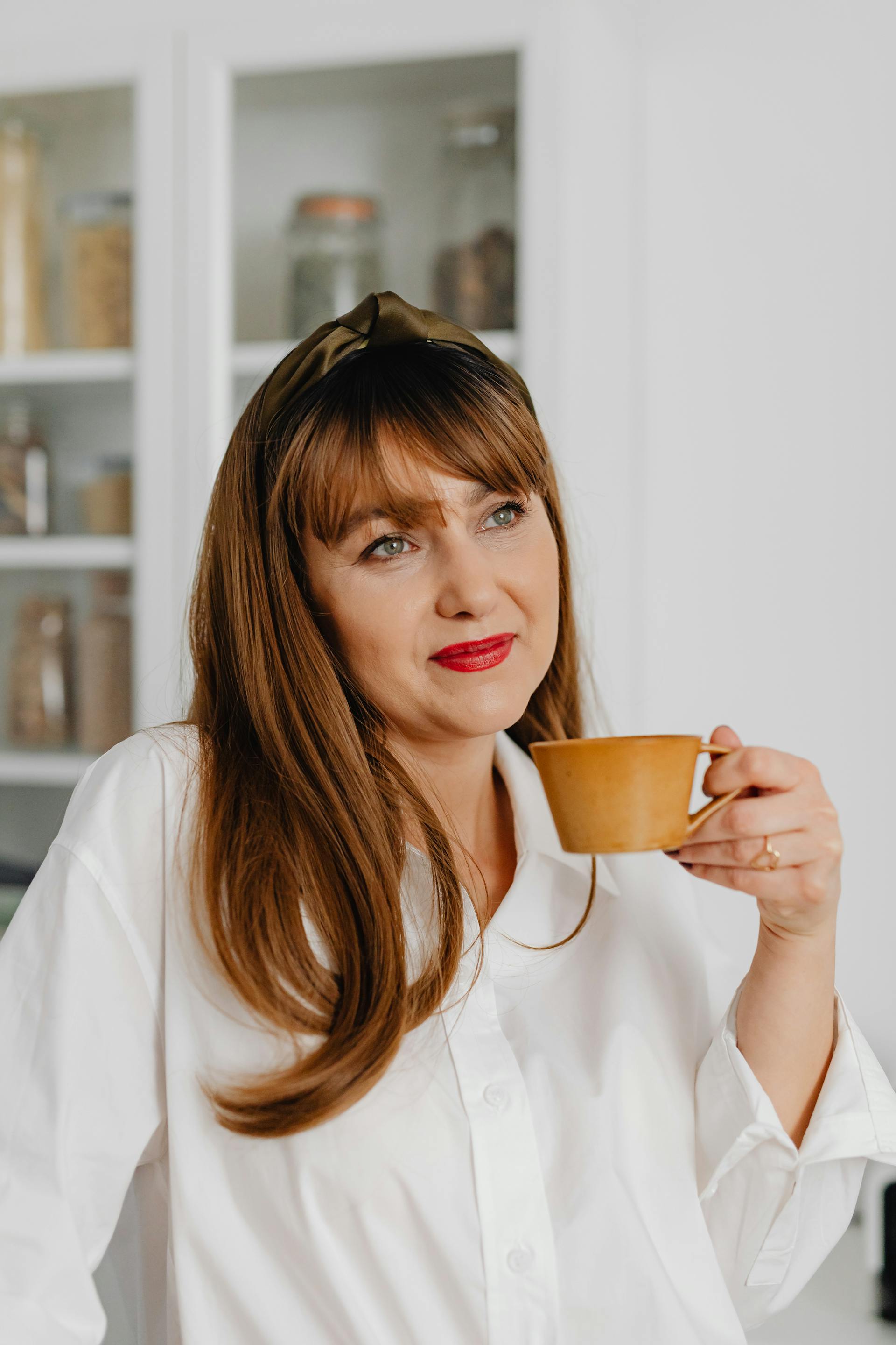 A cheerful woman holding a ceramic cup | Source: Pexels