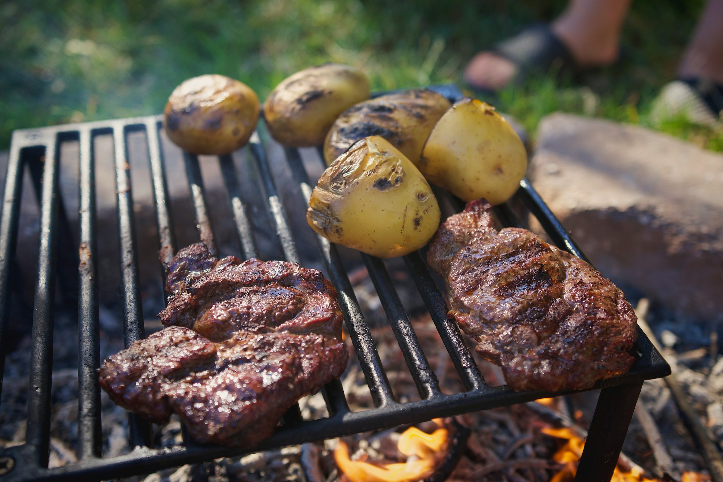 Meat and potatoes on a grill | Source: Unsplash