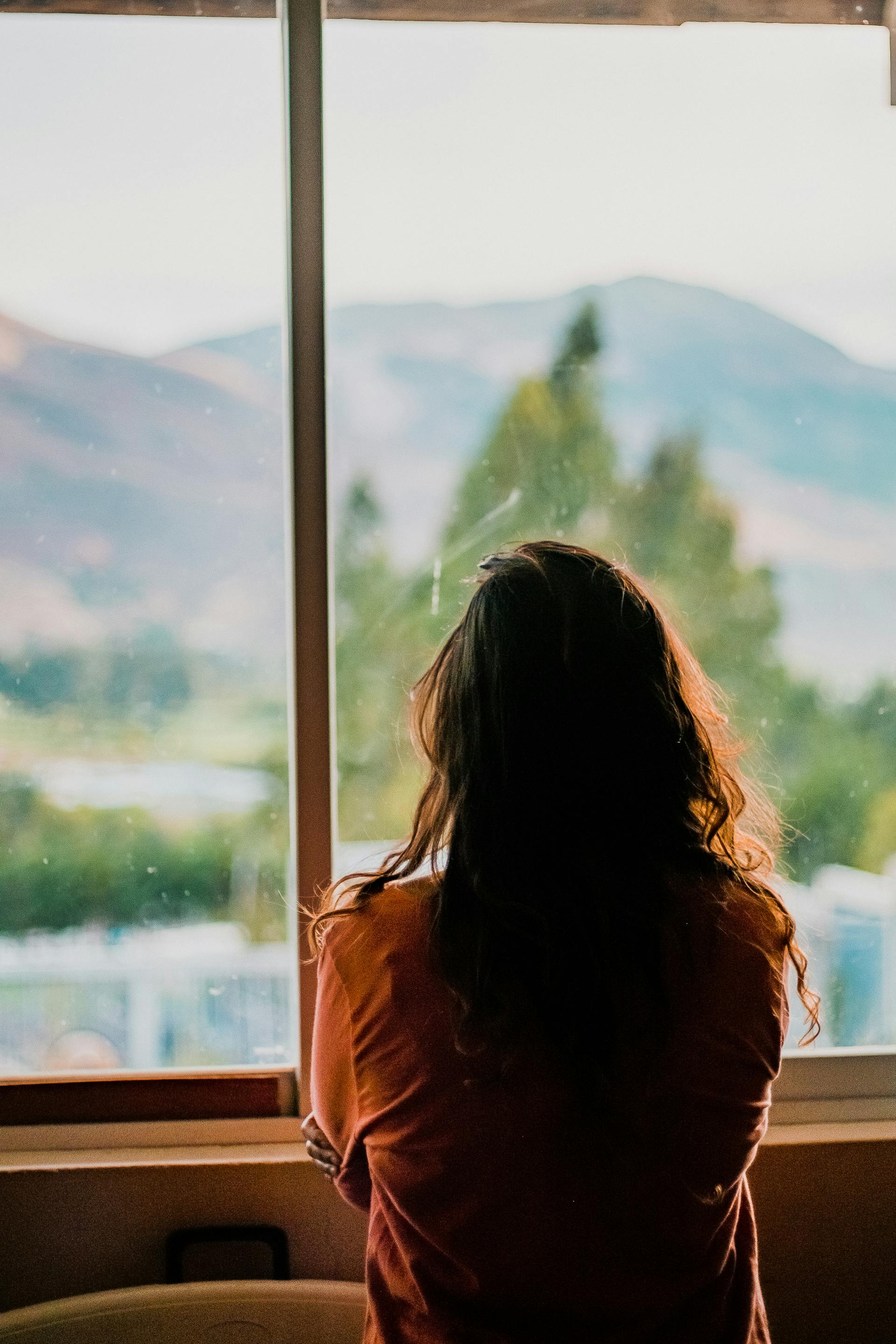 Une femme regardant par la fenêtre | Source : Pexels