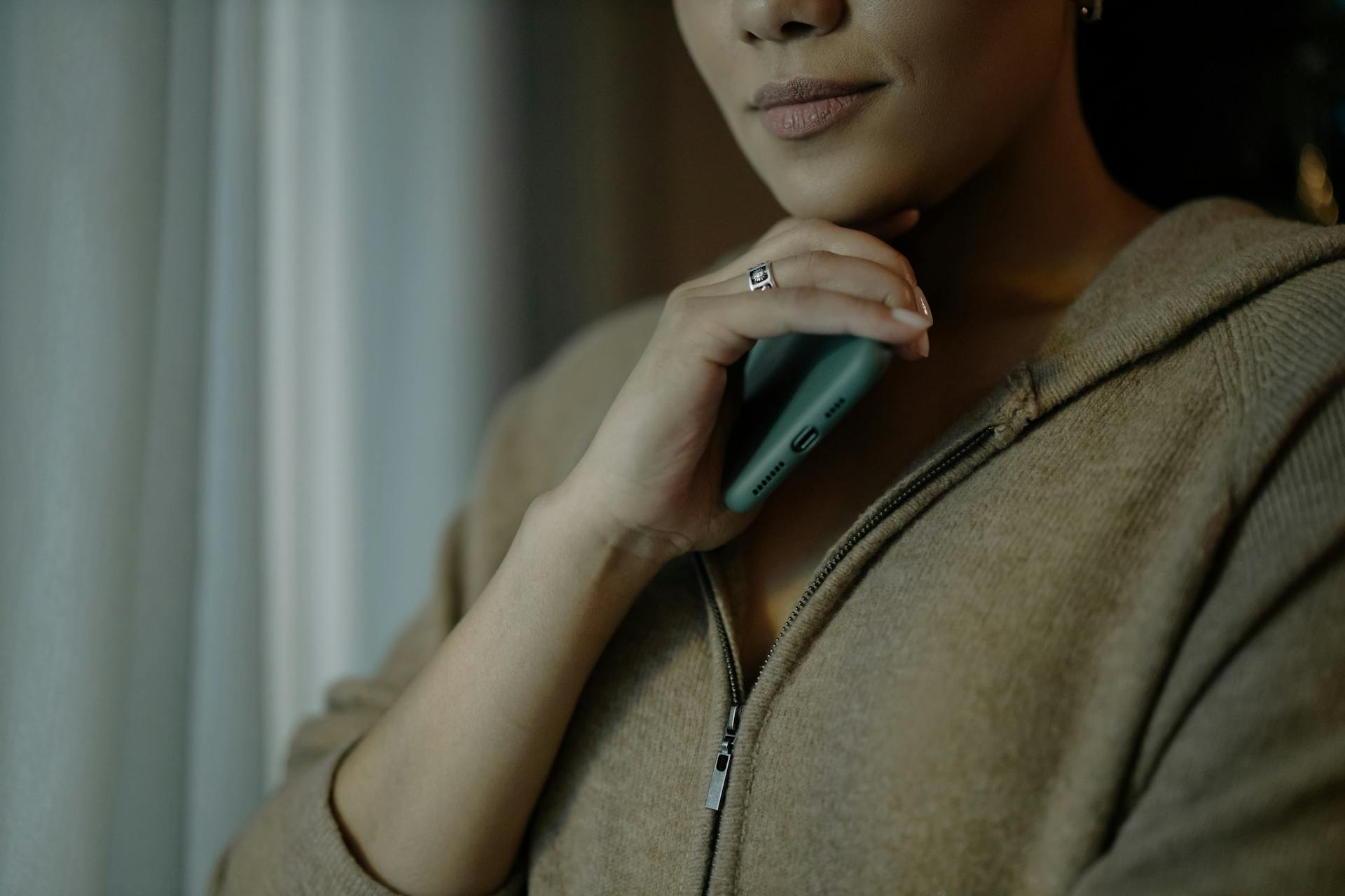 A woman holding a phone while deepi in thought | Source: Pexels