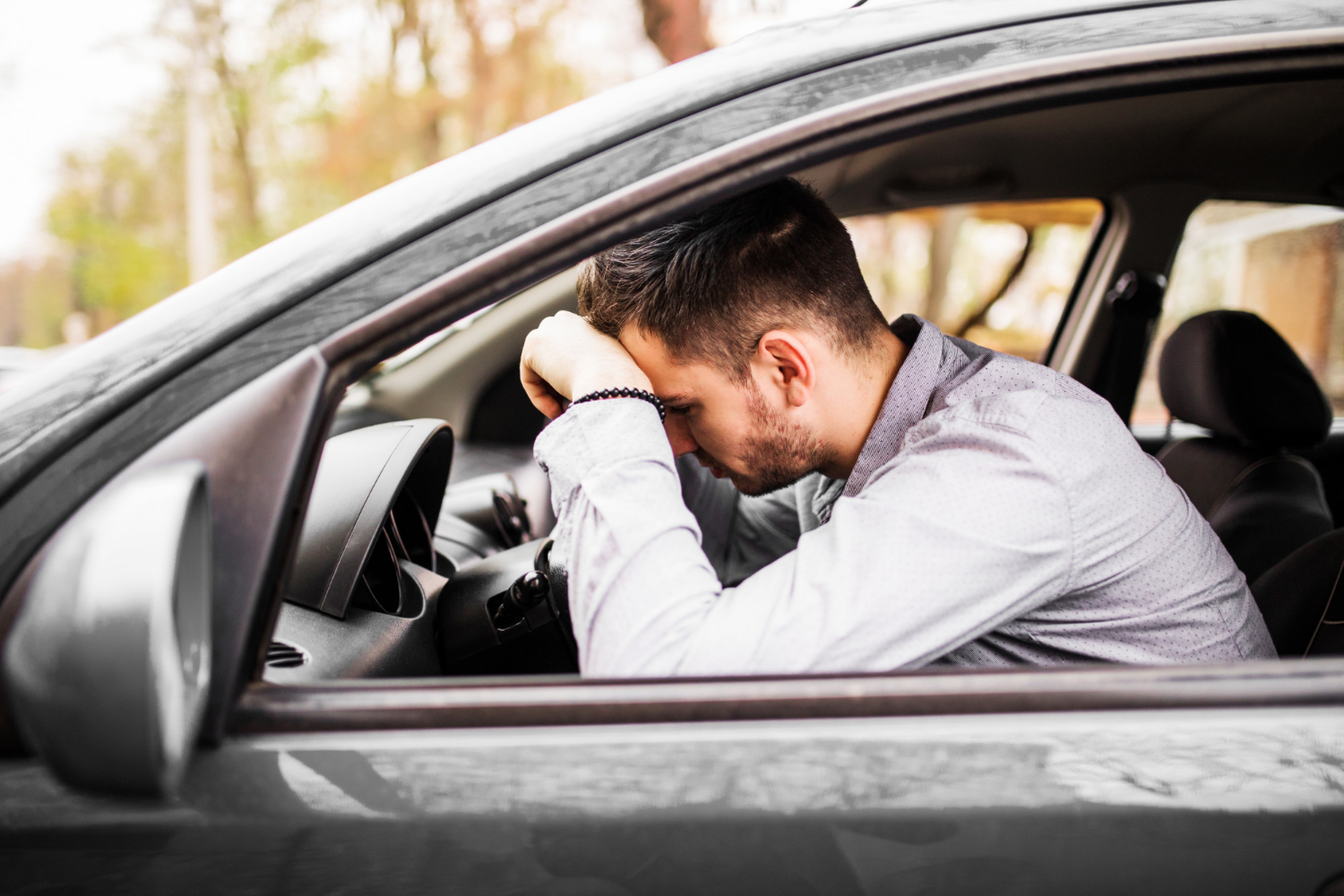 A distressed man sitting in his car | Source: Freepik