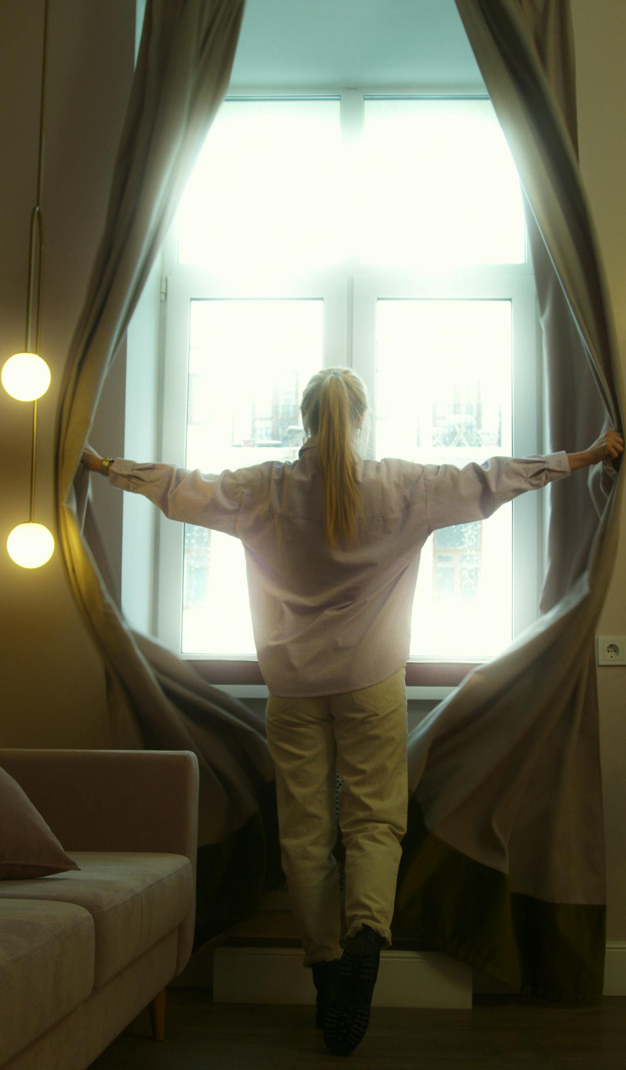 A woman opening the curtain | Source: Pexels