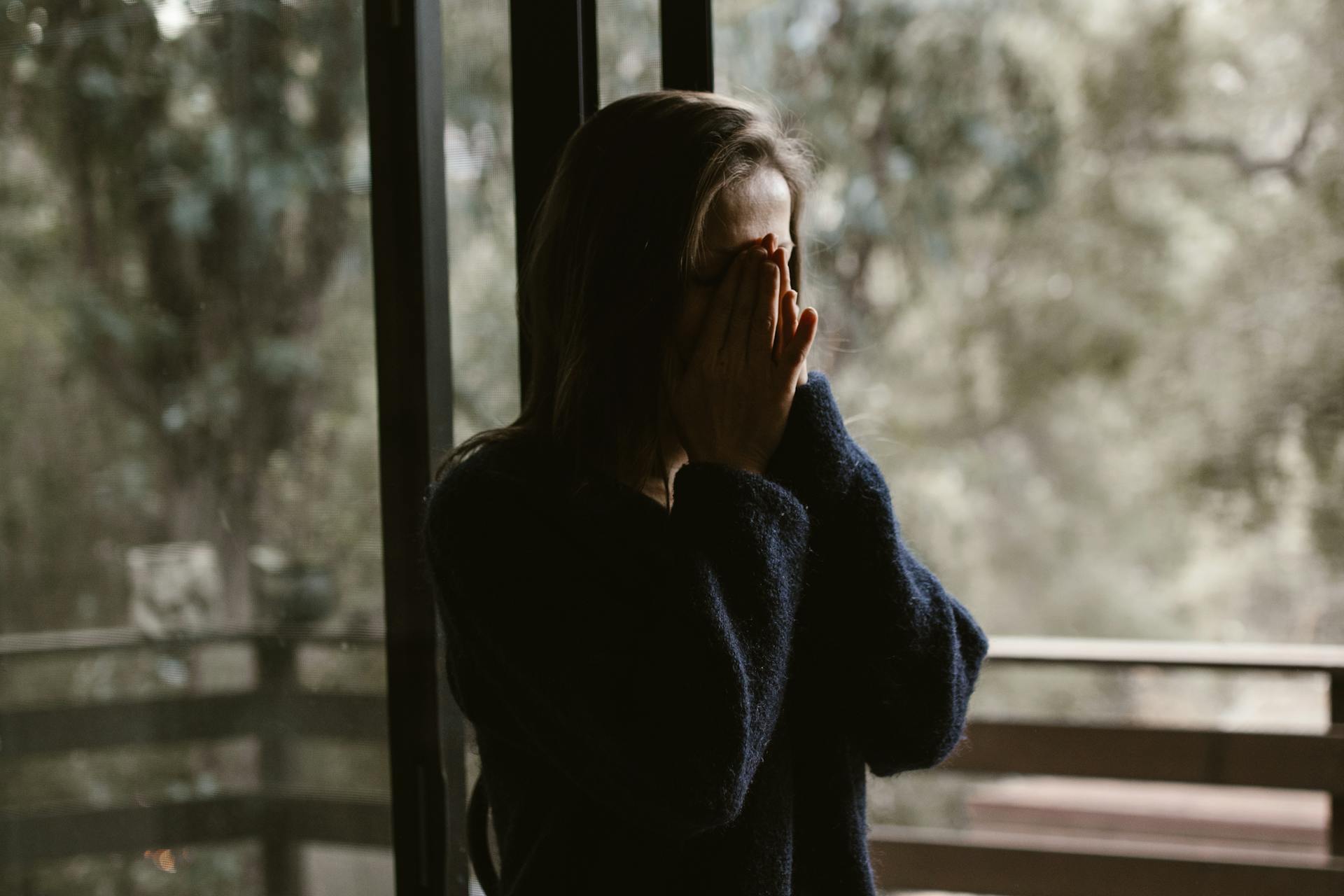 A woman covering her face with her hands | Source: Pexels
