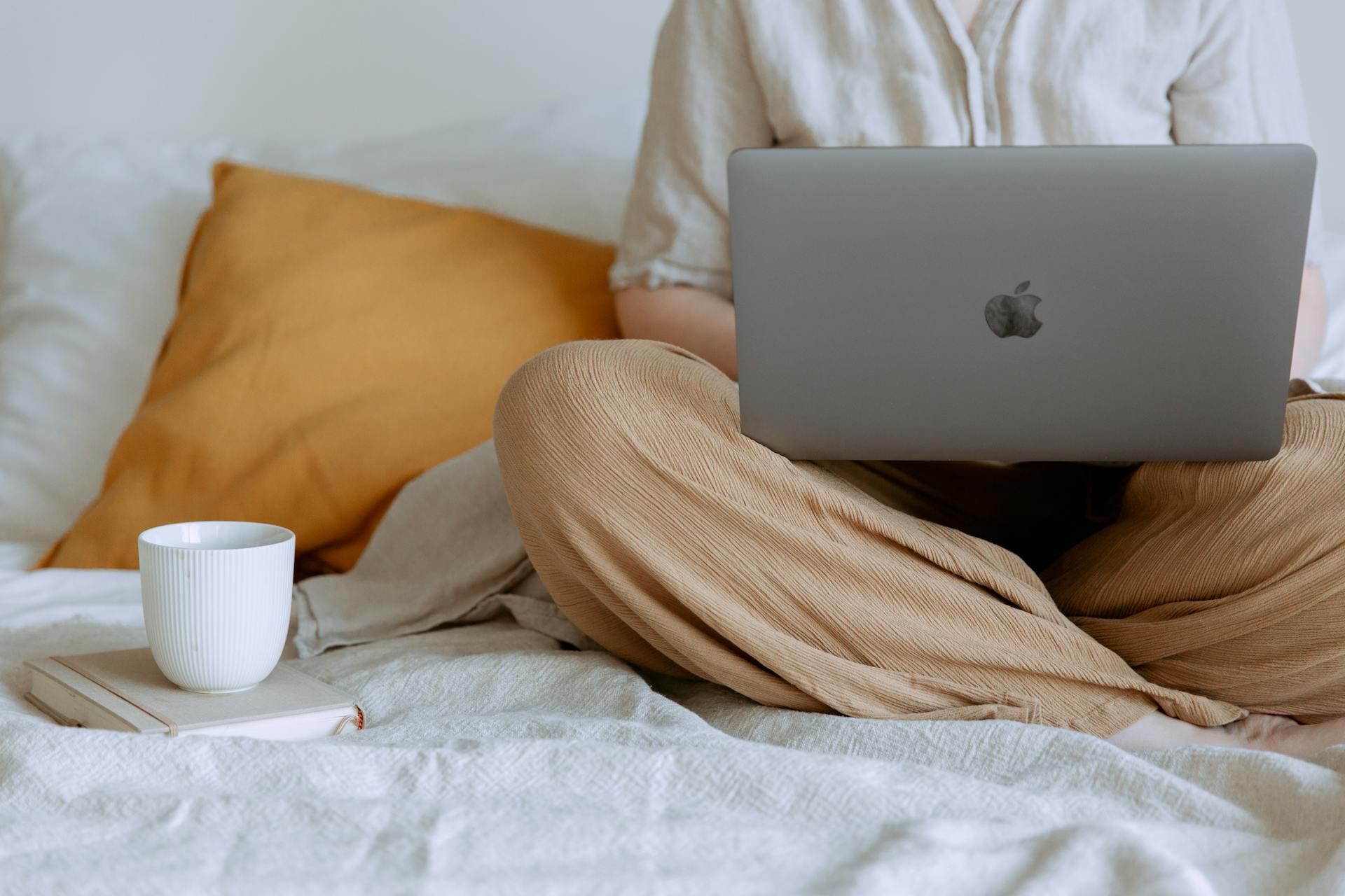A close-up shot of a woman working on her laptop while sitting in bed | Source: Pexels