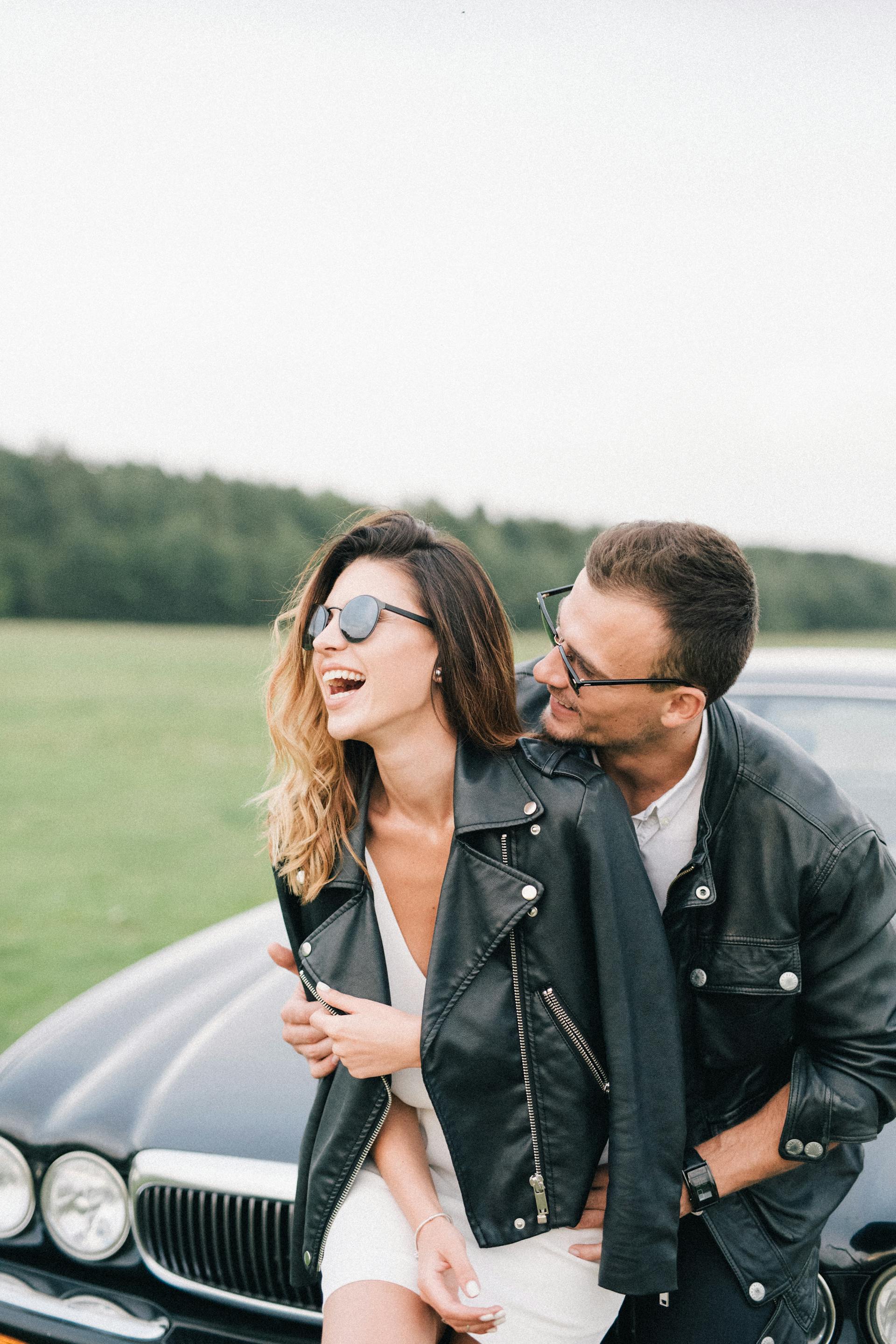 A happy couple standing in front of a car | Source: Pexels