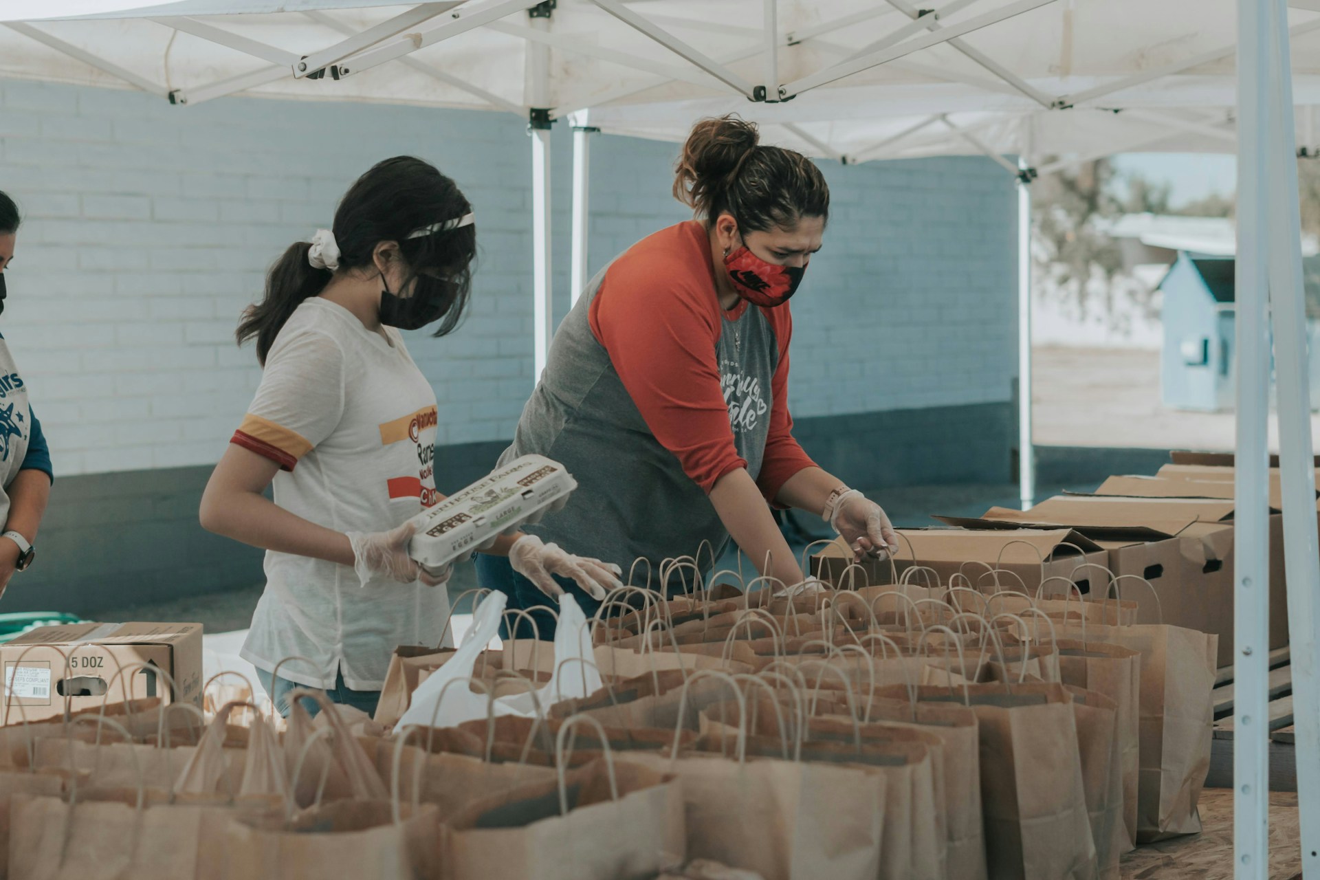 Volunteers packing donated items into bags | Source: Unsplash