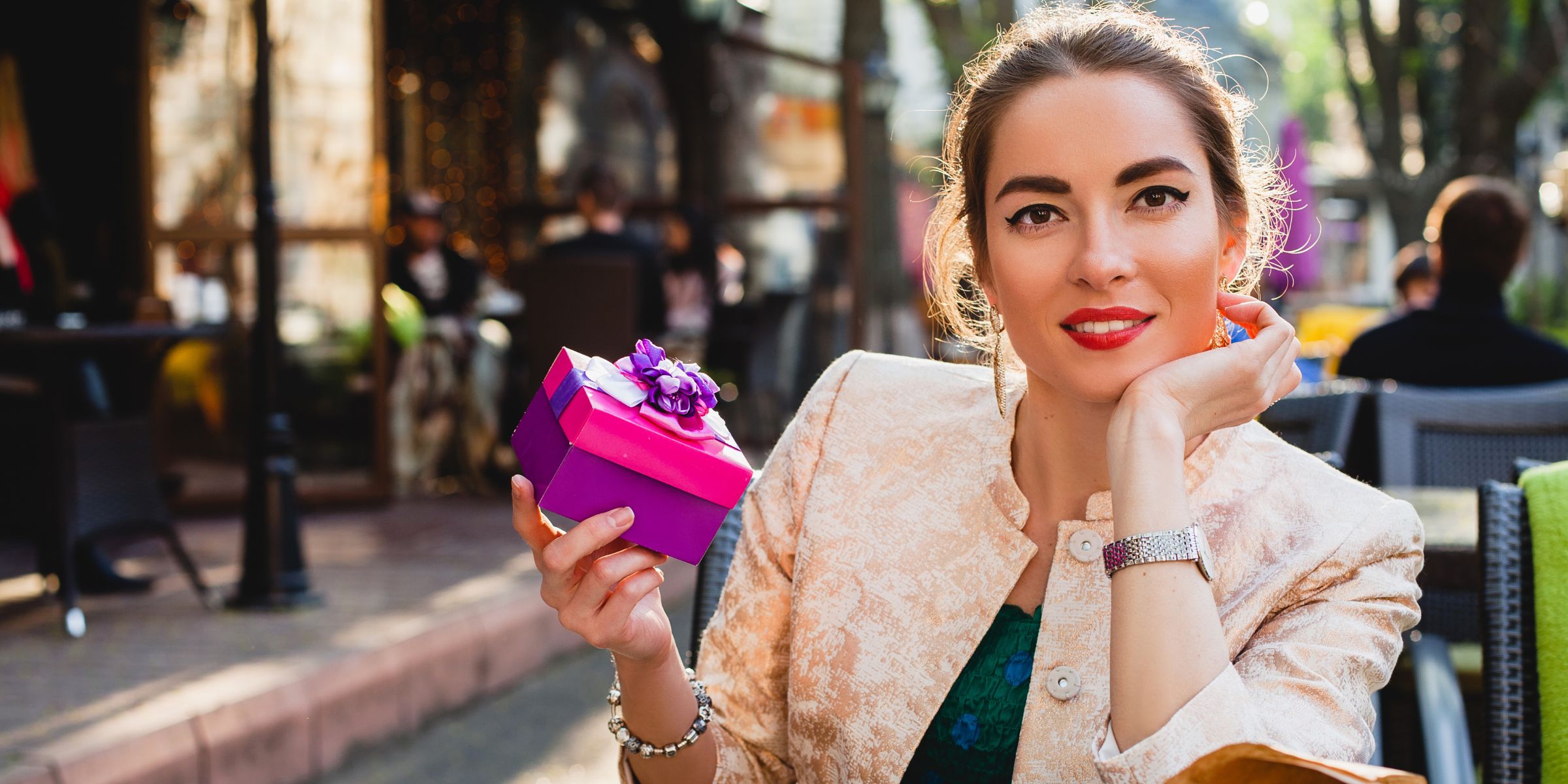 A smiling woman holding a giftbox | Source: Magnific