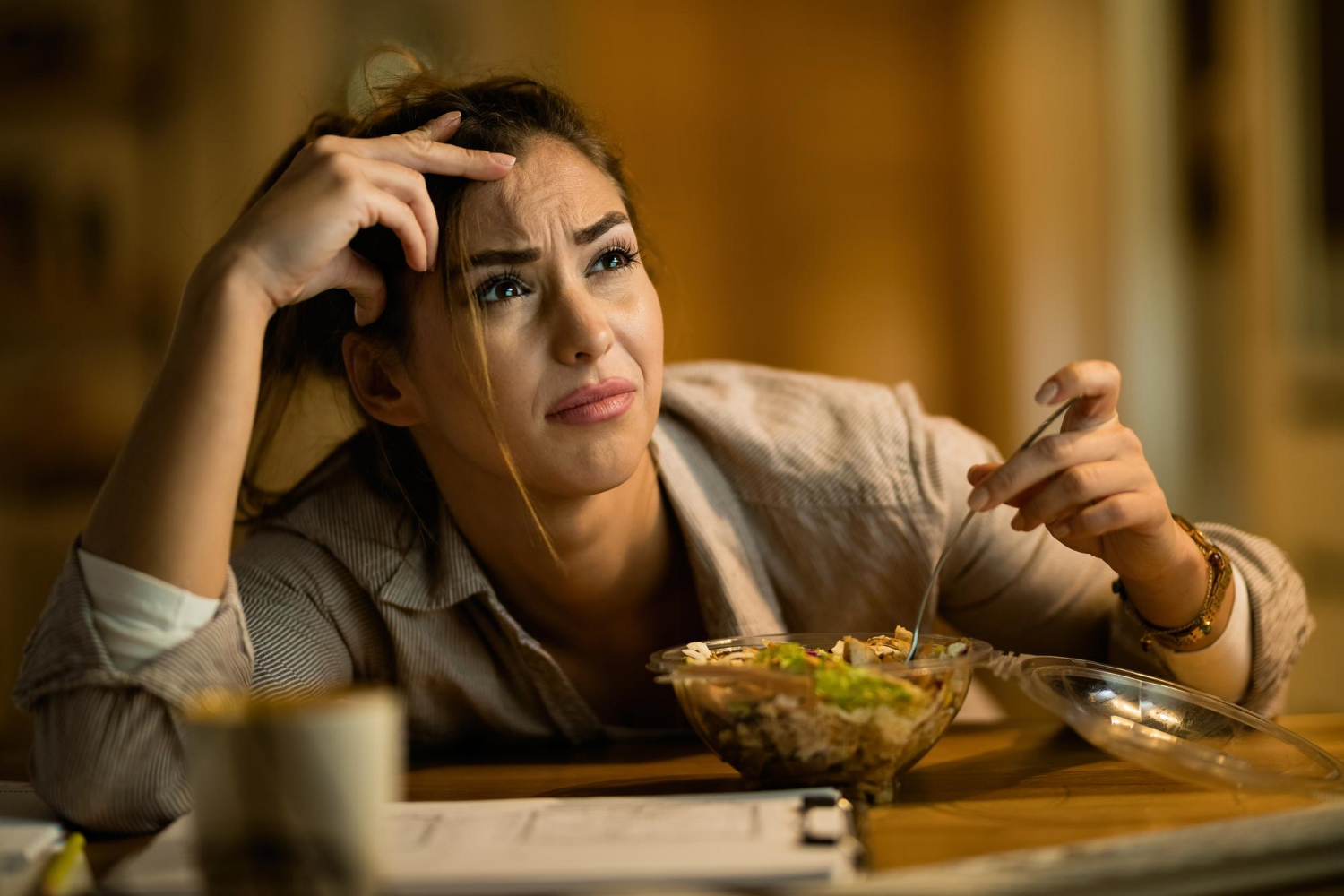 A displeased woman seated at the dining table | Source: Freepik
