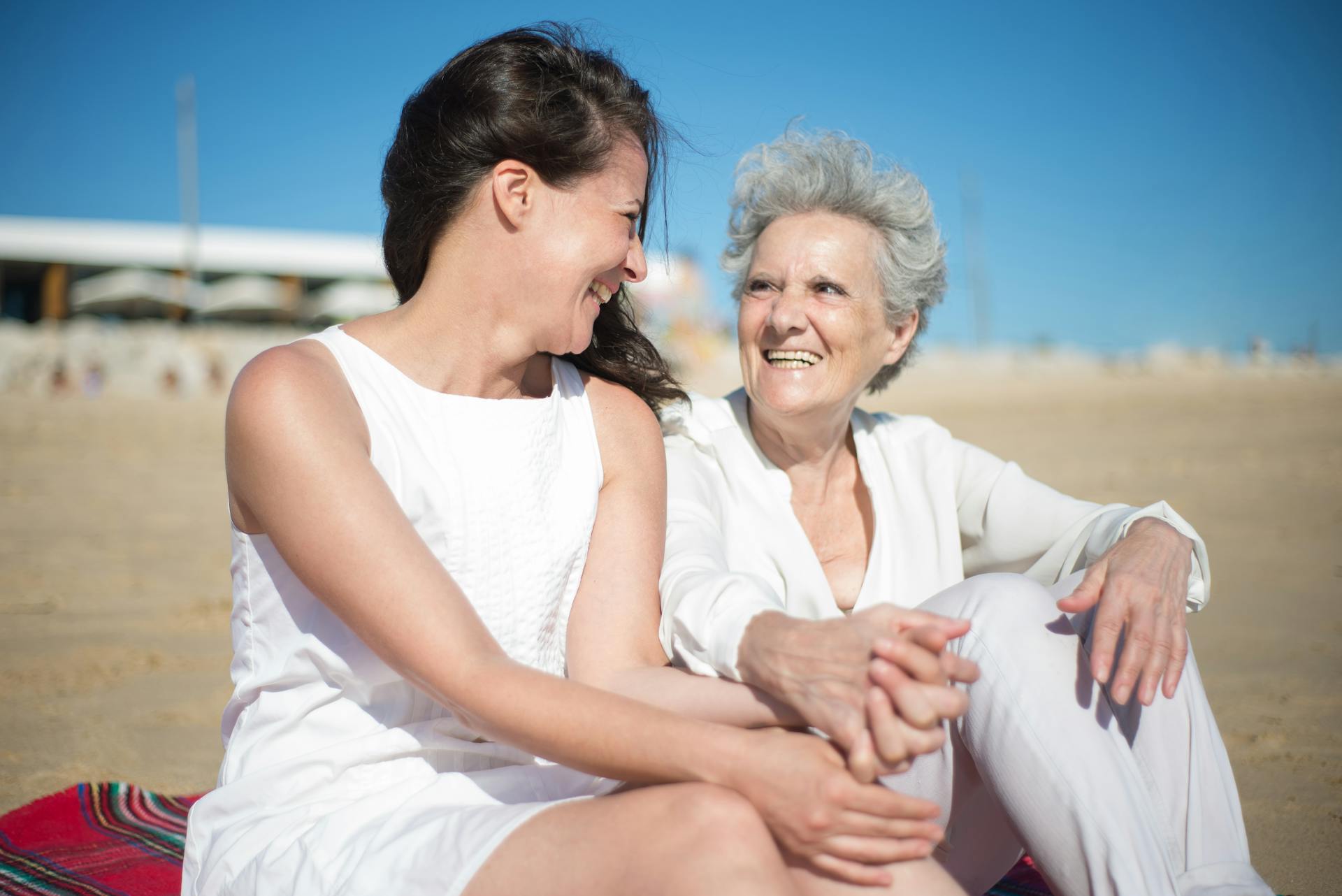A mother-daughter duo sitting on the beach | Source: Pexels