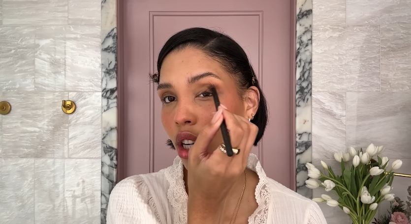 Nara Smith doing her makeup routine from a video dated December 12, 2024. | Source: YouTube/Vogue