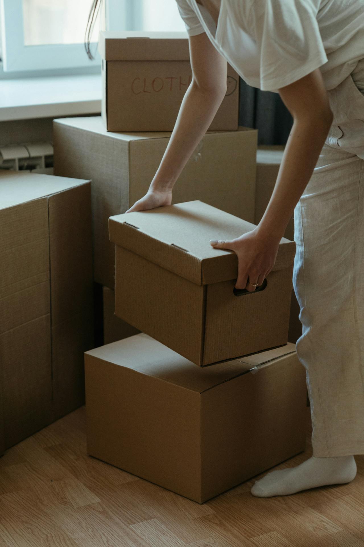 A woman holding a cardboard box | Source: Pexels
