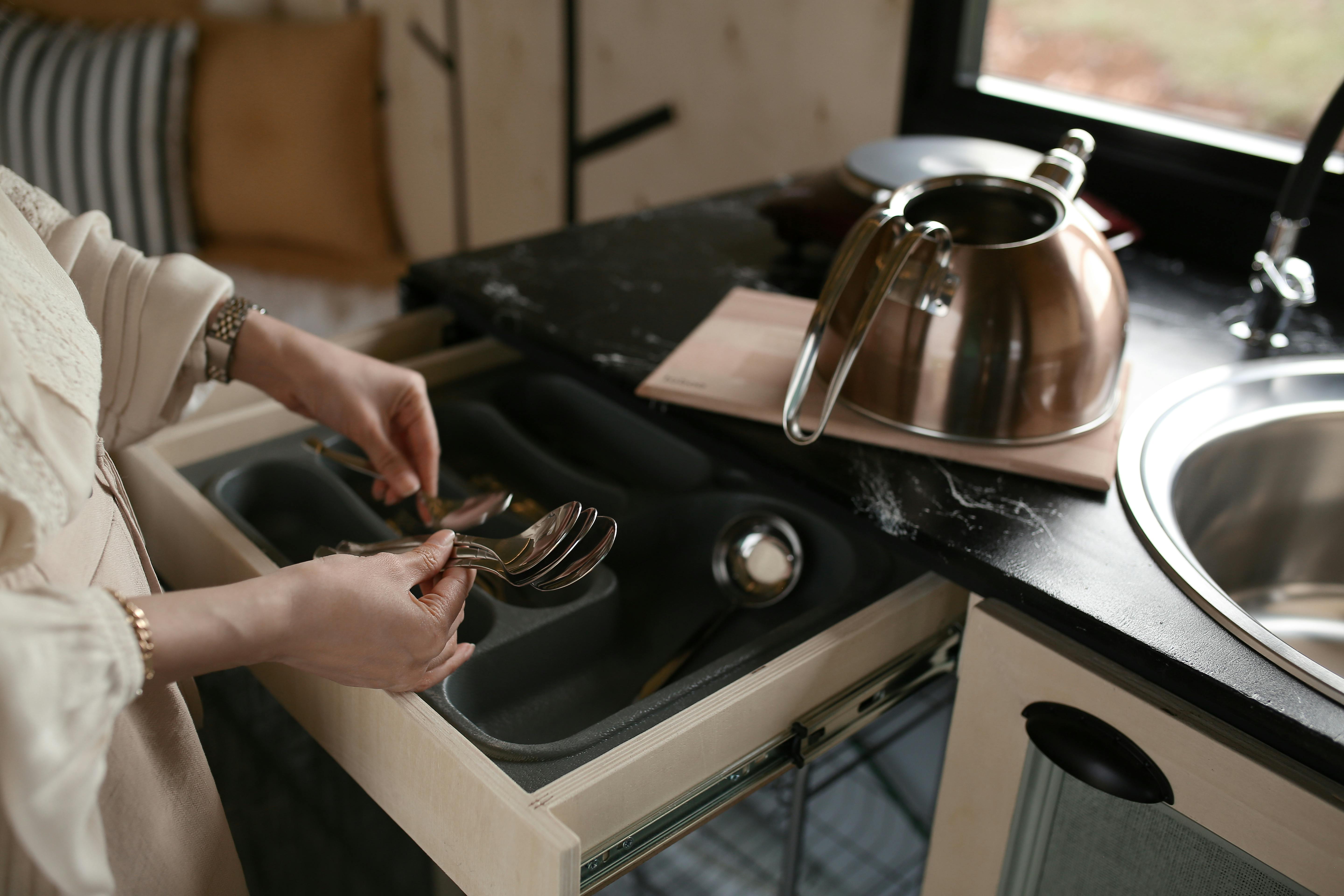 A person arranging a cutlery drawer | Source: Pexels