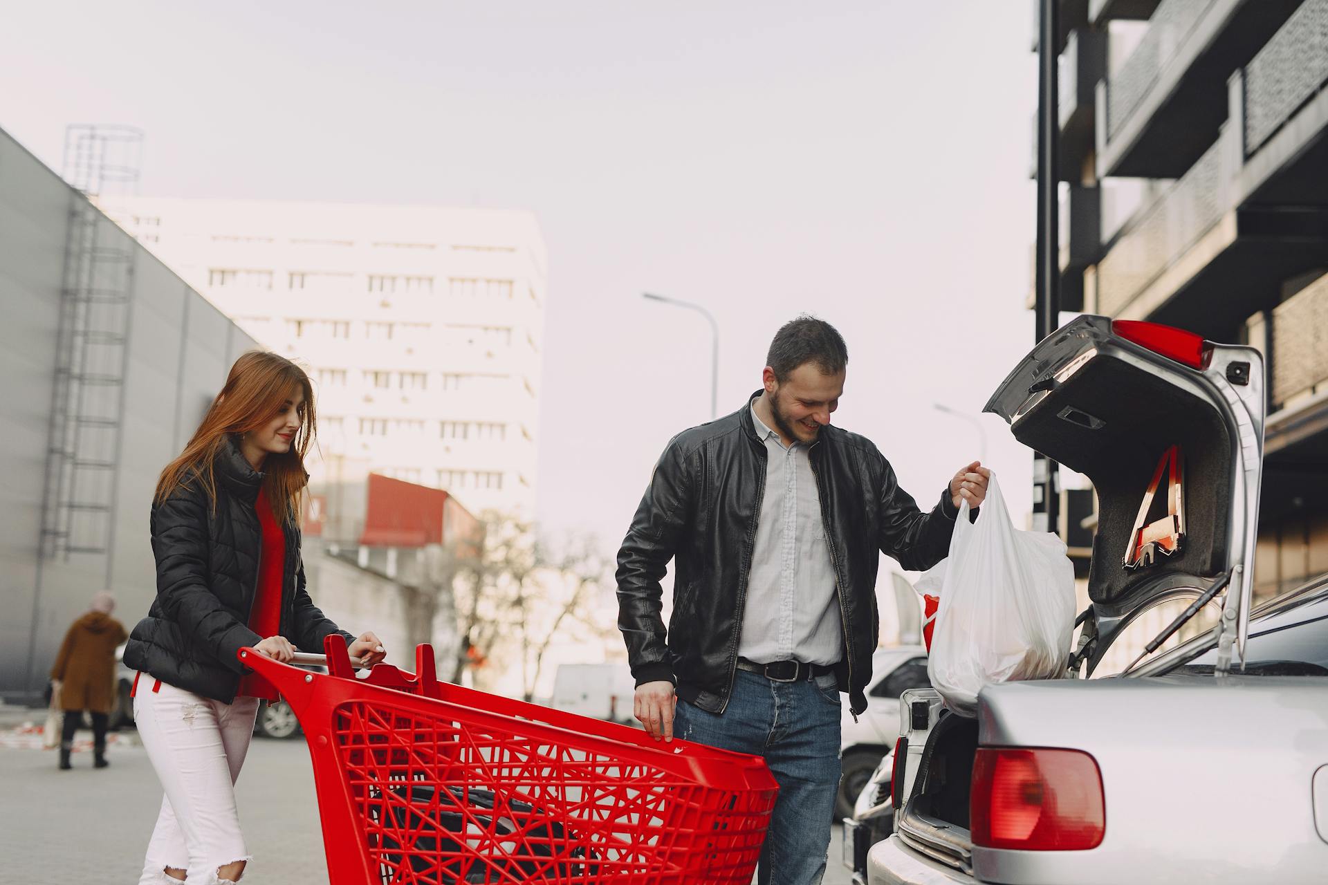 A man helping to load bags into a woman's car | Source: Pexels